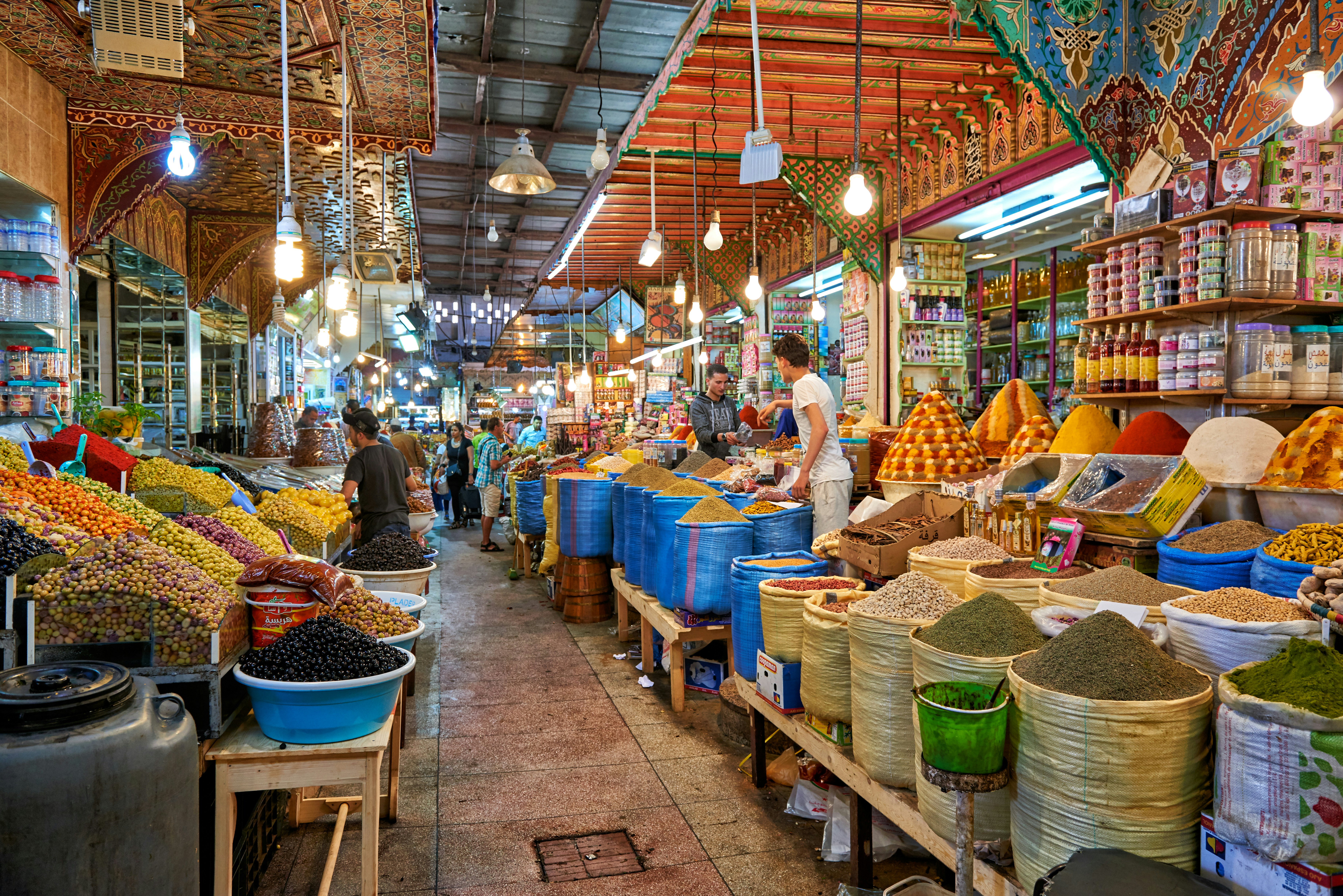 A walkway through stalls selling food and spices at a souq in Morocco.