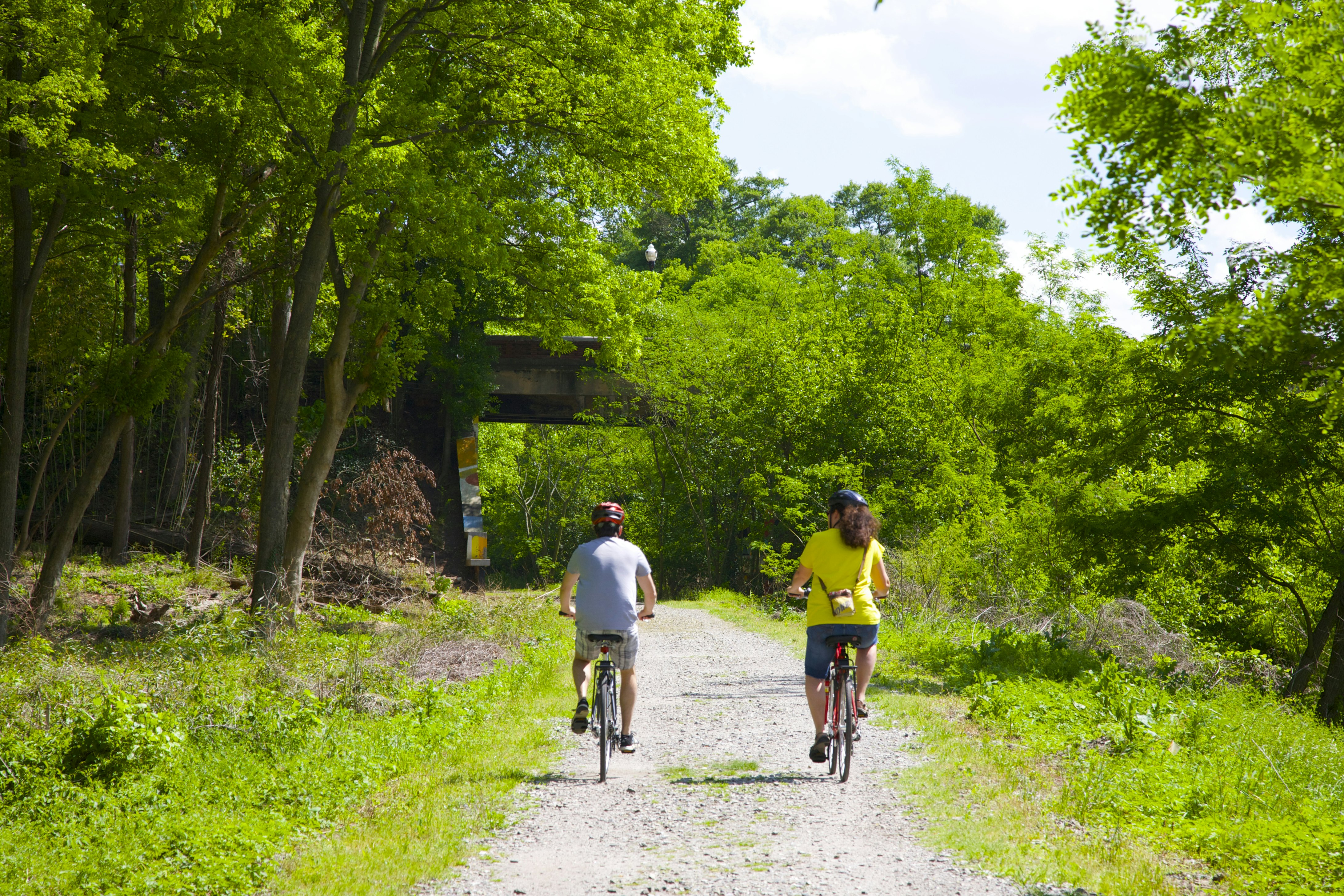 Man and woman riding bicycles in a park on the Atlanta Beltline
