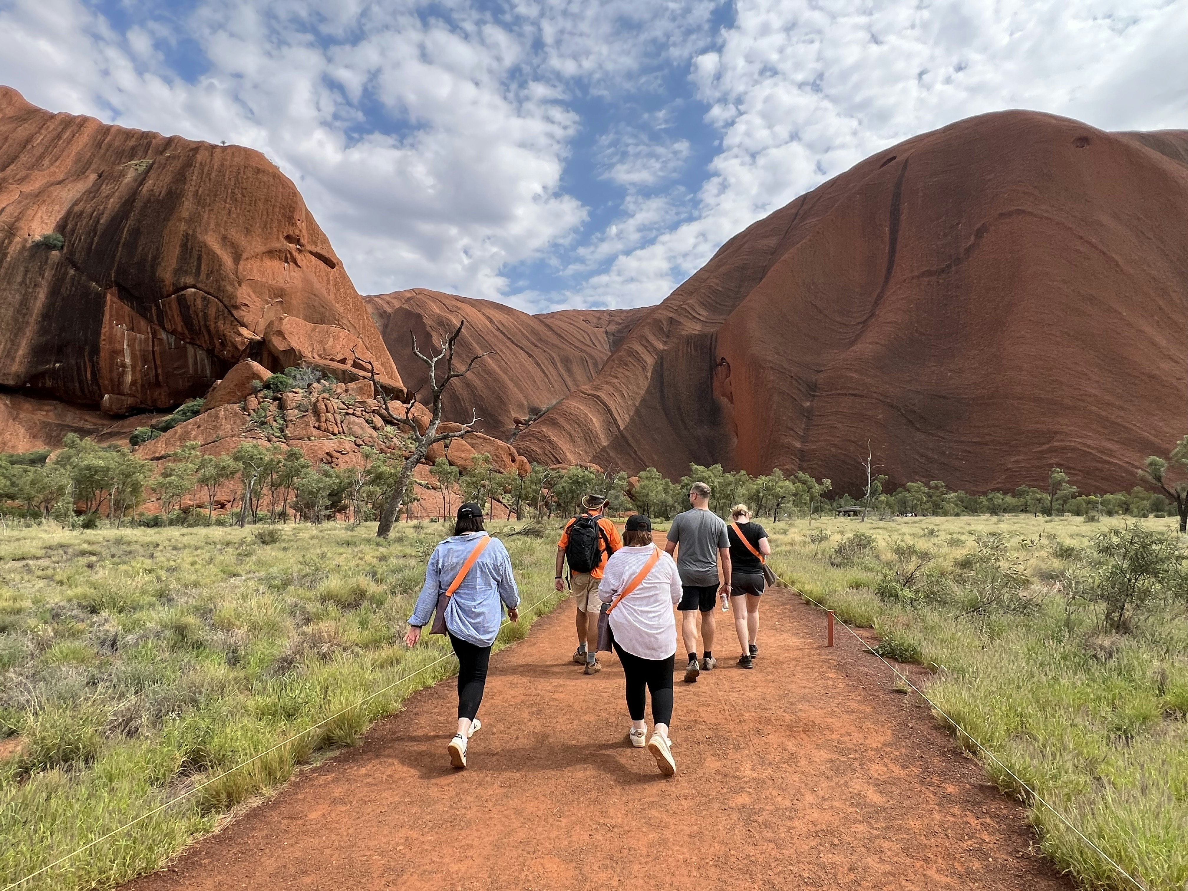 Tourists walk towards Uluru in Uluru-Kata Tjuta National Park.
