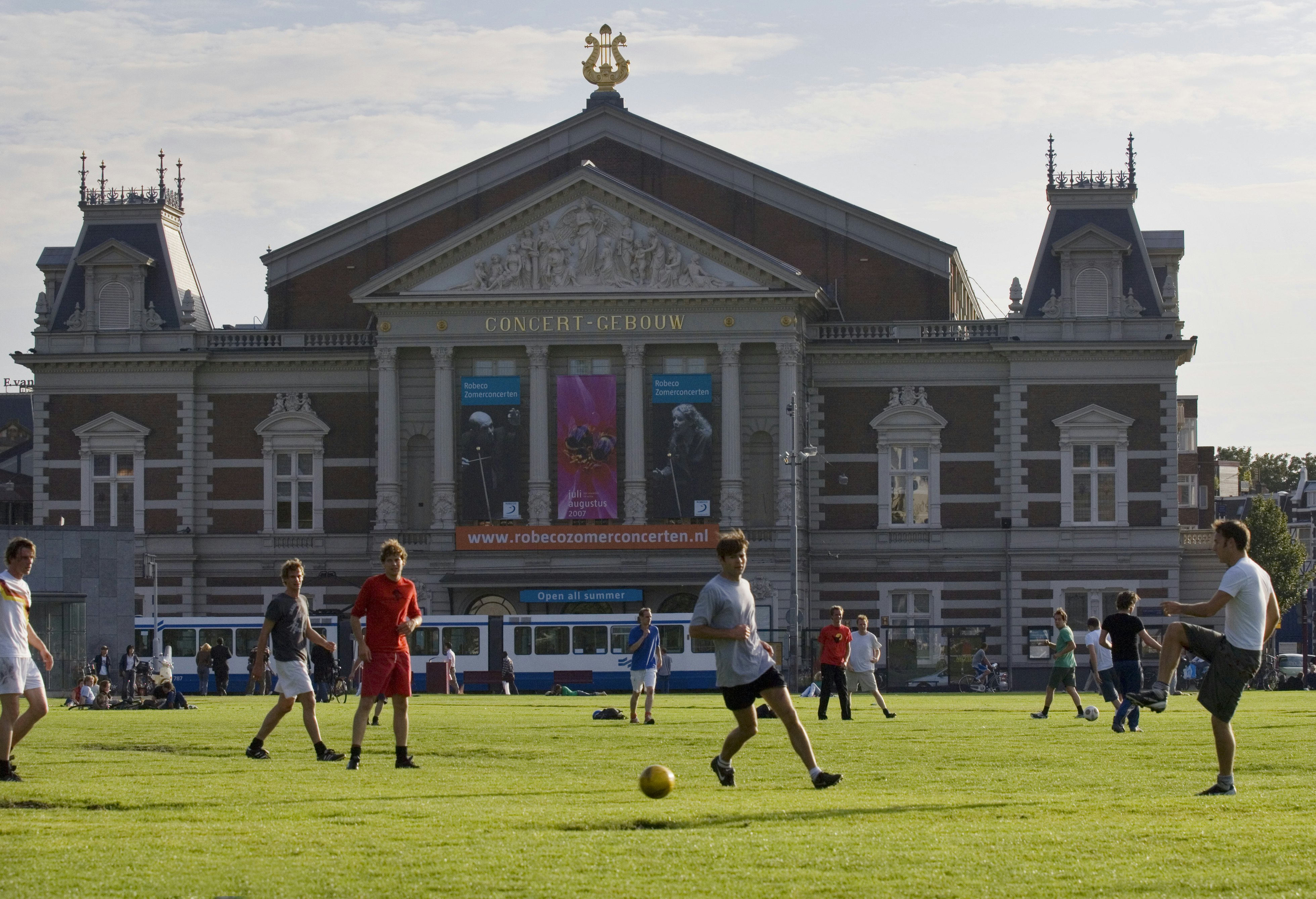 Young men playing soccer with Concertgebouw in background