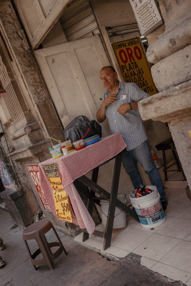 A man sells tacos at a stand