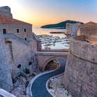 Old city walls and Old Harbour of Dubrovnik at sunset in Dubrovnik, Croatia License Type: media Download Time: 2021-04-22T04:16:28.000Z User: Is Editorial: No purchase_order: