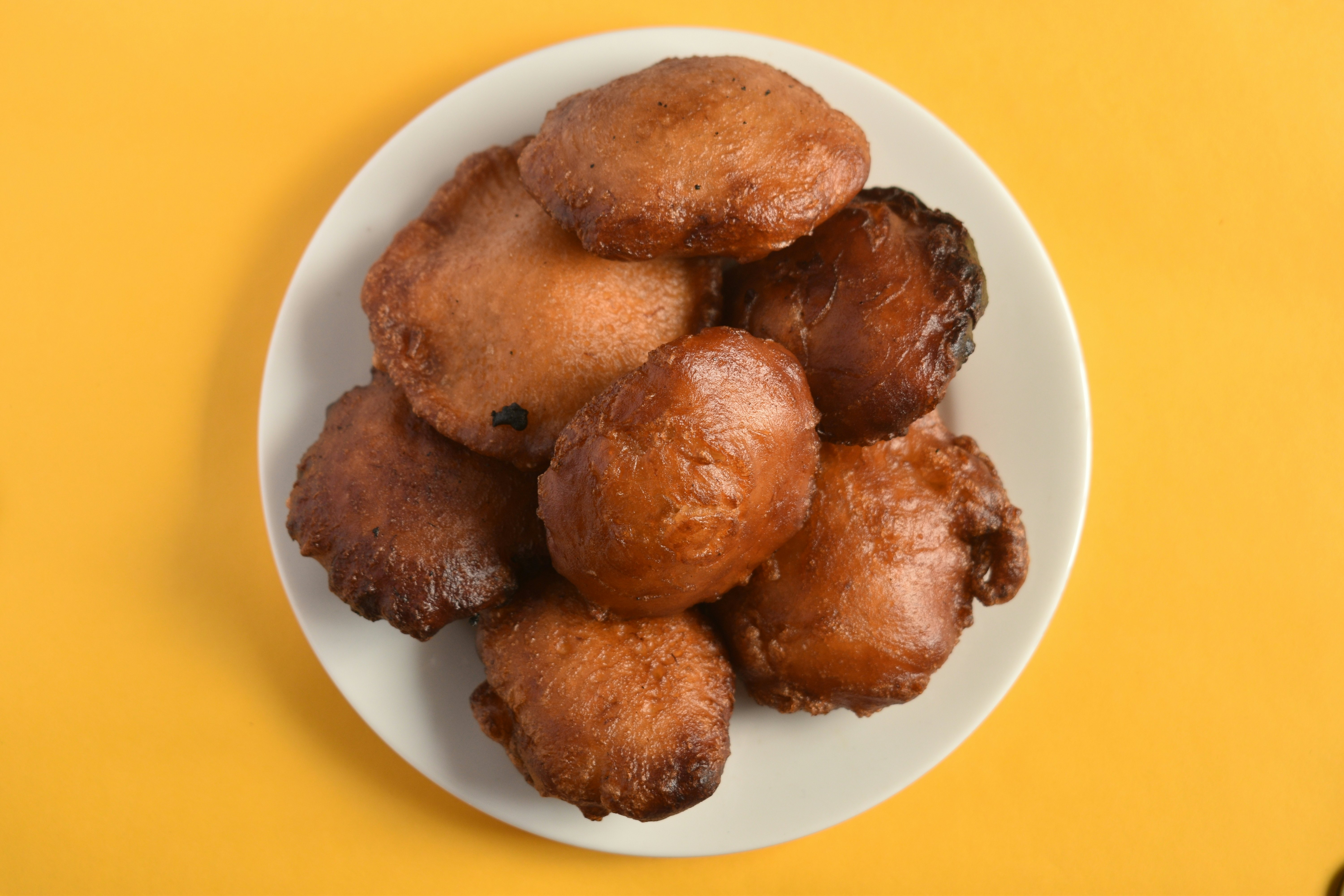 Sri Lankan kevum dessert on white plate on yellow background