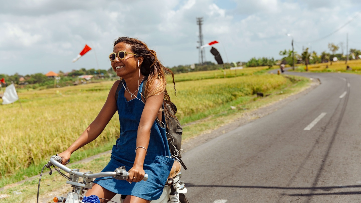 Woman riding bicycle in Bali.