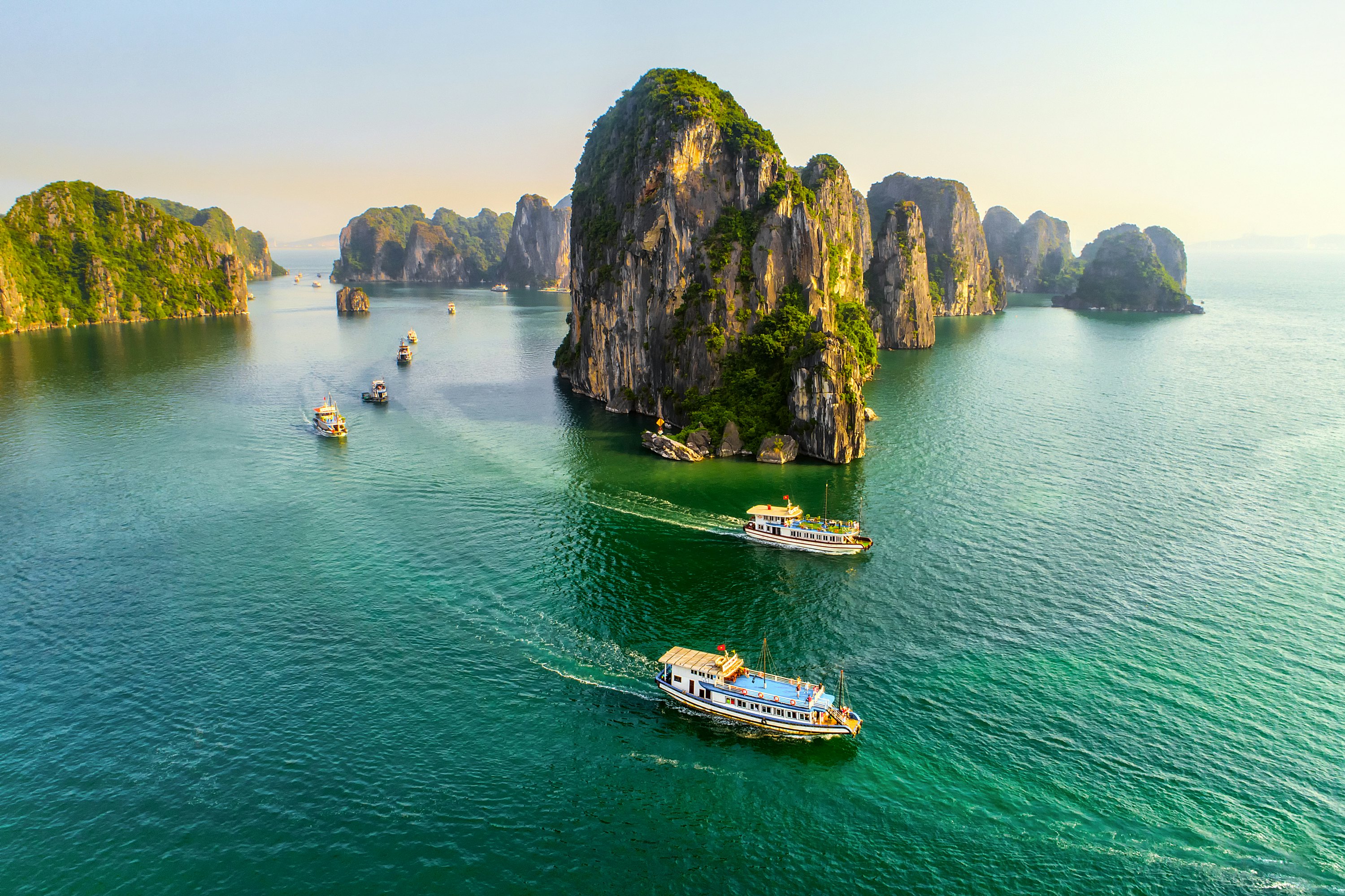 Aerial view of Halong Bay with boats in the bright teal water