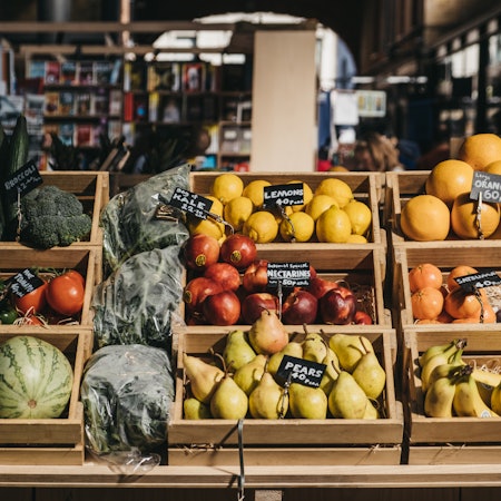 Fresh fruits in wooden crates on sale at Spitalfields Market, one of the finest surviving Victorian Market Halls in London with fashion, antiques and food stalls.