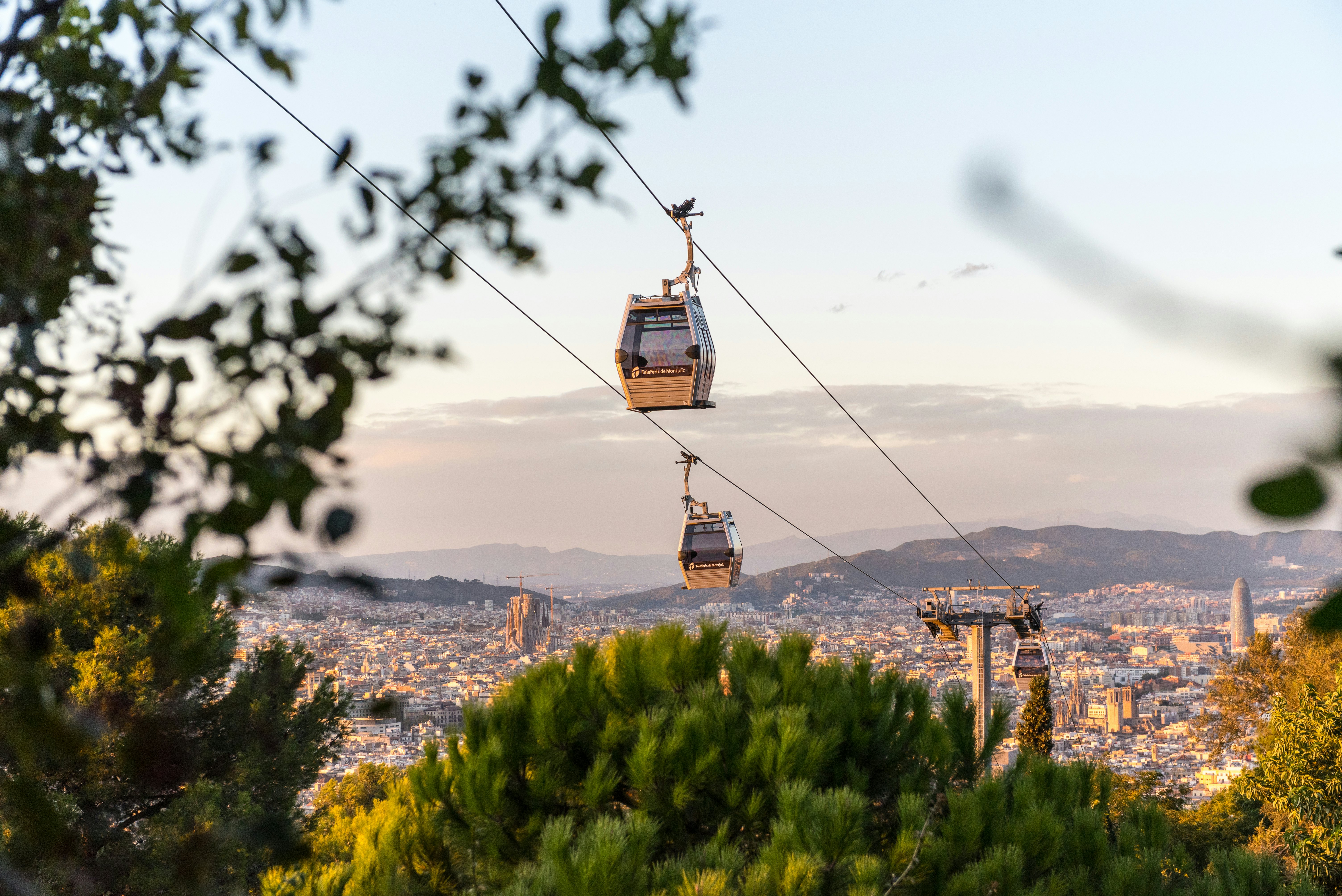 A cable car travels across a city landscape.