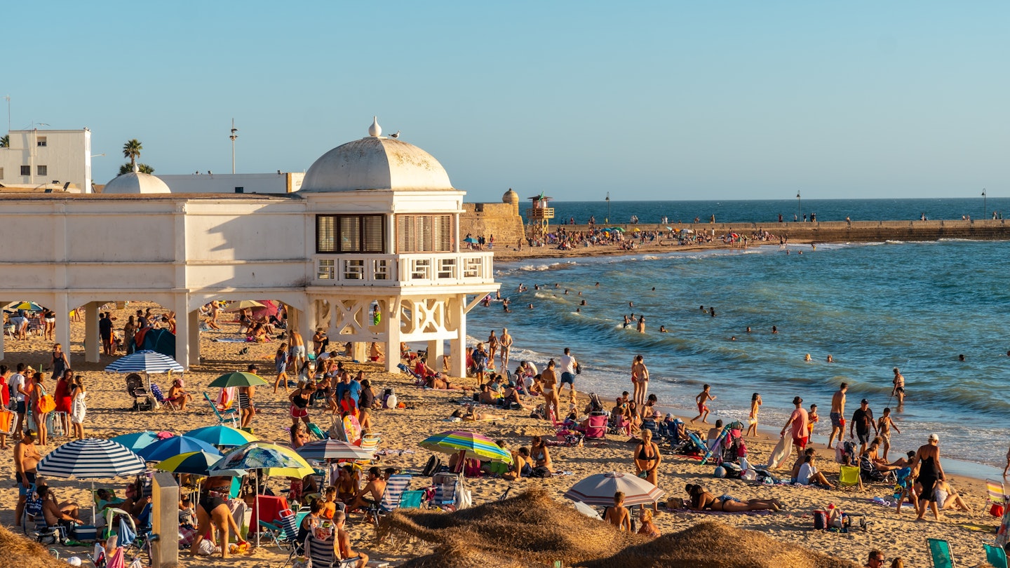 Cadiz, Andalucia, Spain: August 2022: Bathers on the beach of La Caleta in the summer sunset of the city of Cadiz. Andalusia, License Type: media, Download Time: 2025-07-16T09:18:50.000Z, User: sashabrady26, Editorial: true, purchase_order: 65050 - Digital Destinations and Articles, job: Lonely Planet, client: Why visit Cadiz, other: Sasha Brady