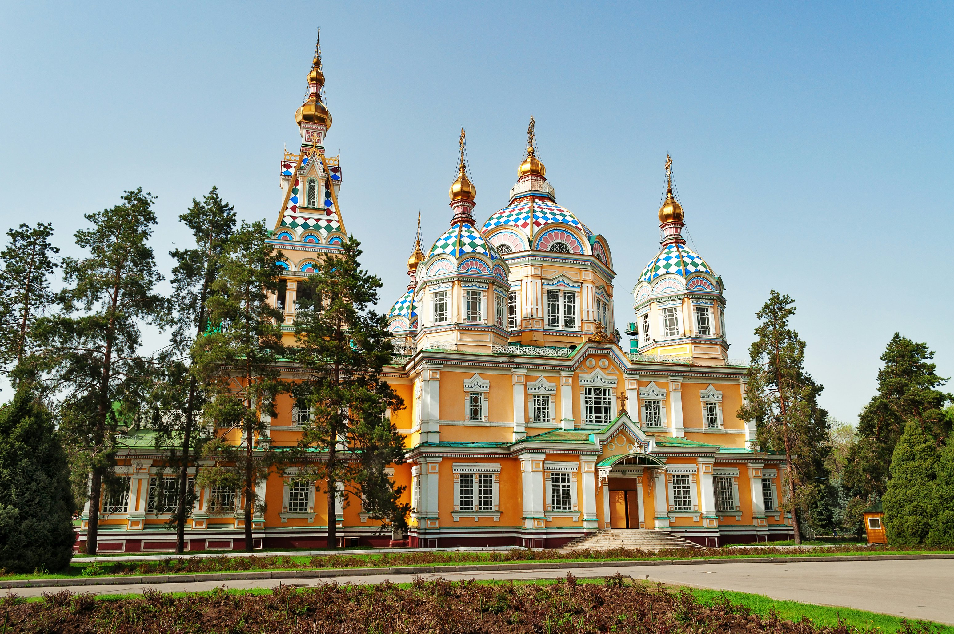 A large Russian Orthodox-style cathedral, with tiled domes and a yellow facade.