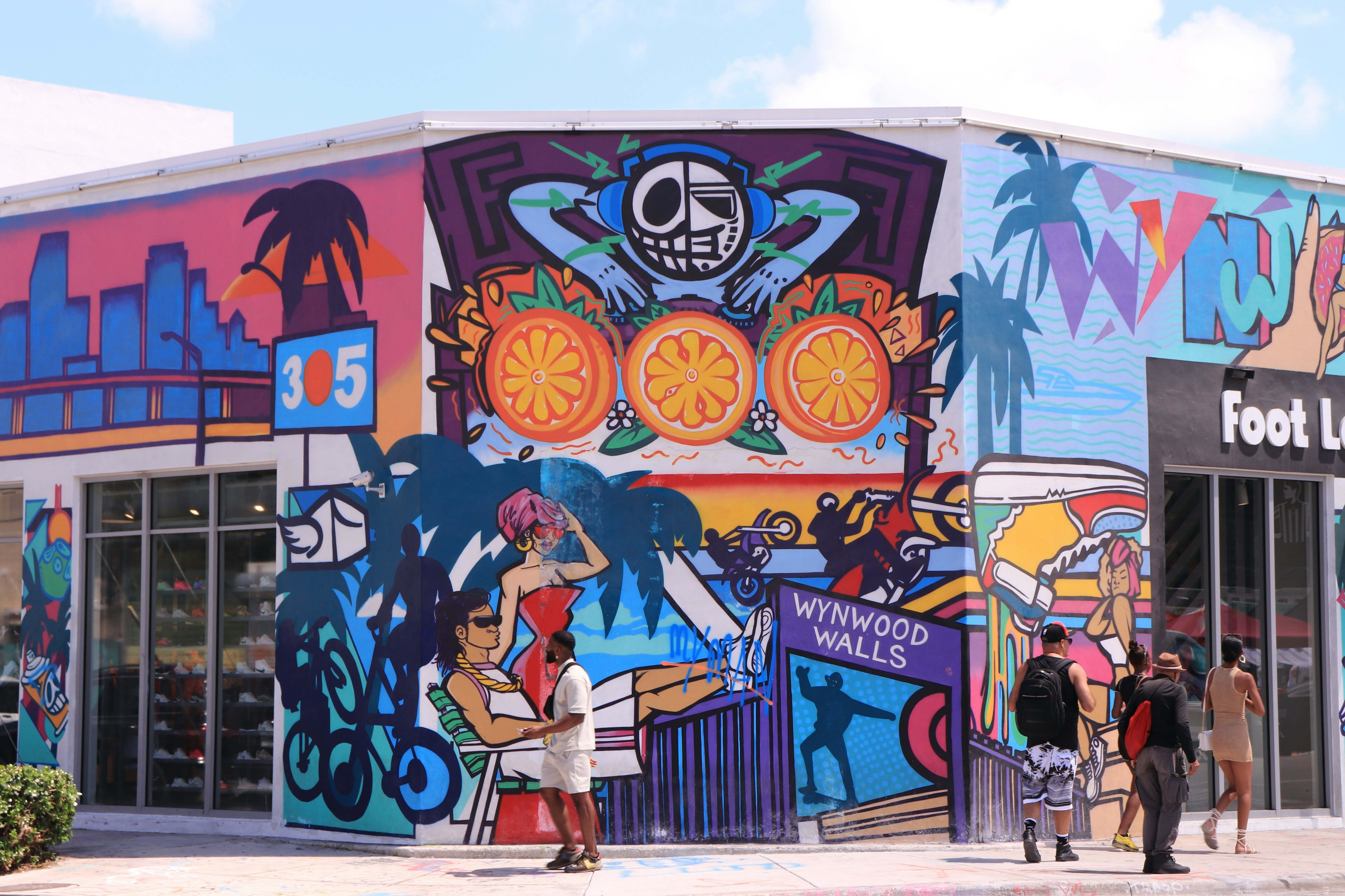 Colorful painted walls of Wynwood Walls in the Wynwood Arts District with people walking nearby.