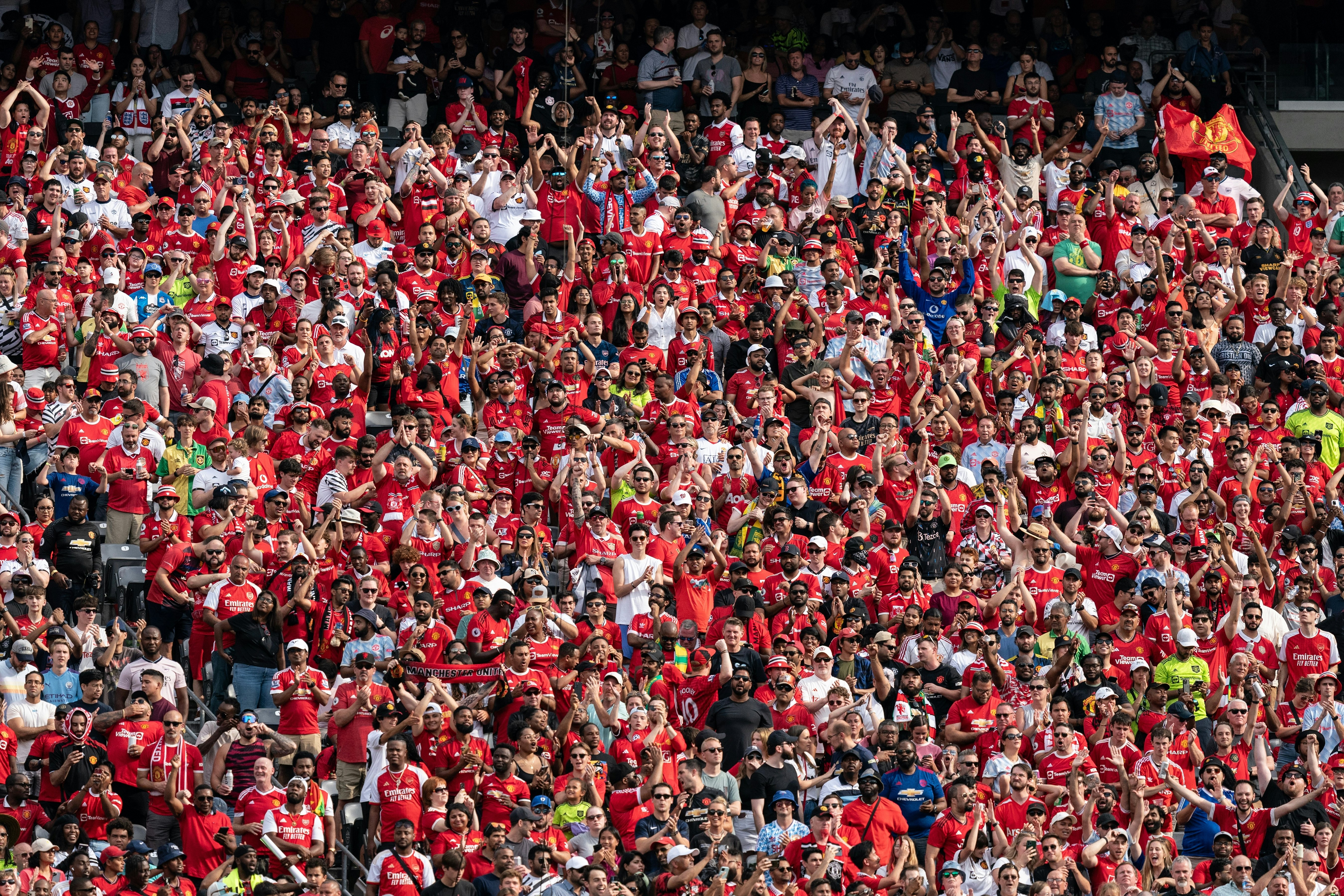 Fans of Arsenal FC and of Manchester United attend a friendly game.