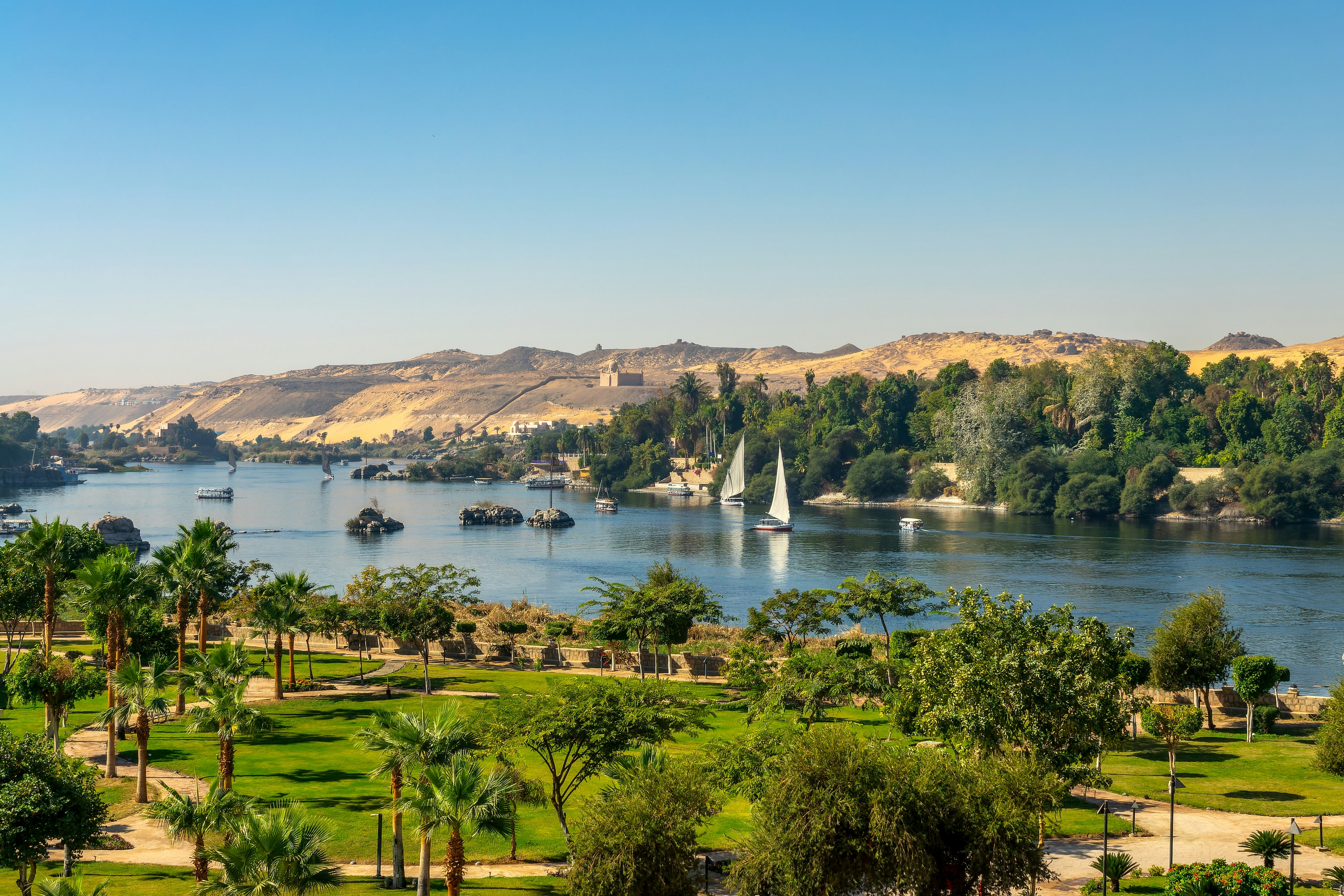 Small sail boats on a wide river.