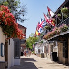 St. Augustine, Florida - April 14, 2025: A busy St. George Street in St. Augustine, Florida, lined with historic buildings, flags, and flowers, License Type: media, Download Time: 2025-07-18T17:12:47.000Z, User: clairenaylor, Editorial: true, purchase_order: 65050 - Digital Destinations and Articles, job: Online editorial, client: St Augustine things to do, other: Claire Naylor