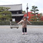 A young girl poses playfully in front of a traditional Japanese temple surrounded by beautifully manicured pine trees and vibrant autumn foliage. Captured during fall season in Kyoto, Japan.; Shutterstock ID 2641309481; purchase_order:65050 - Digital Destinations and Articles; job:Lonely Planet Online Editorial; client:Kyoto with kids; other:Brian Healy
2641309481