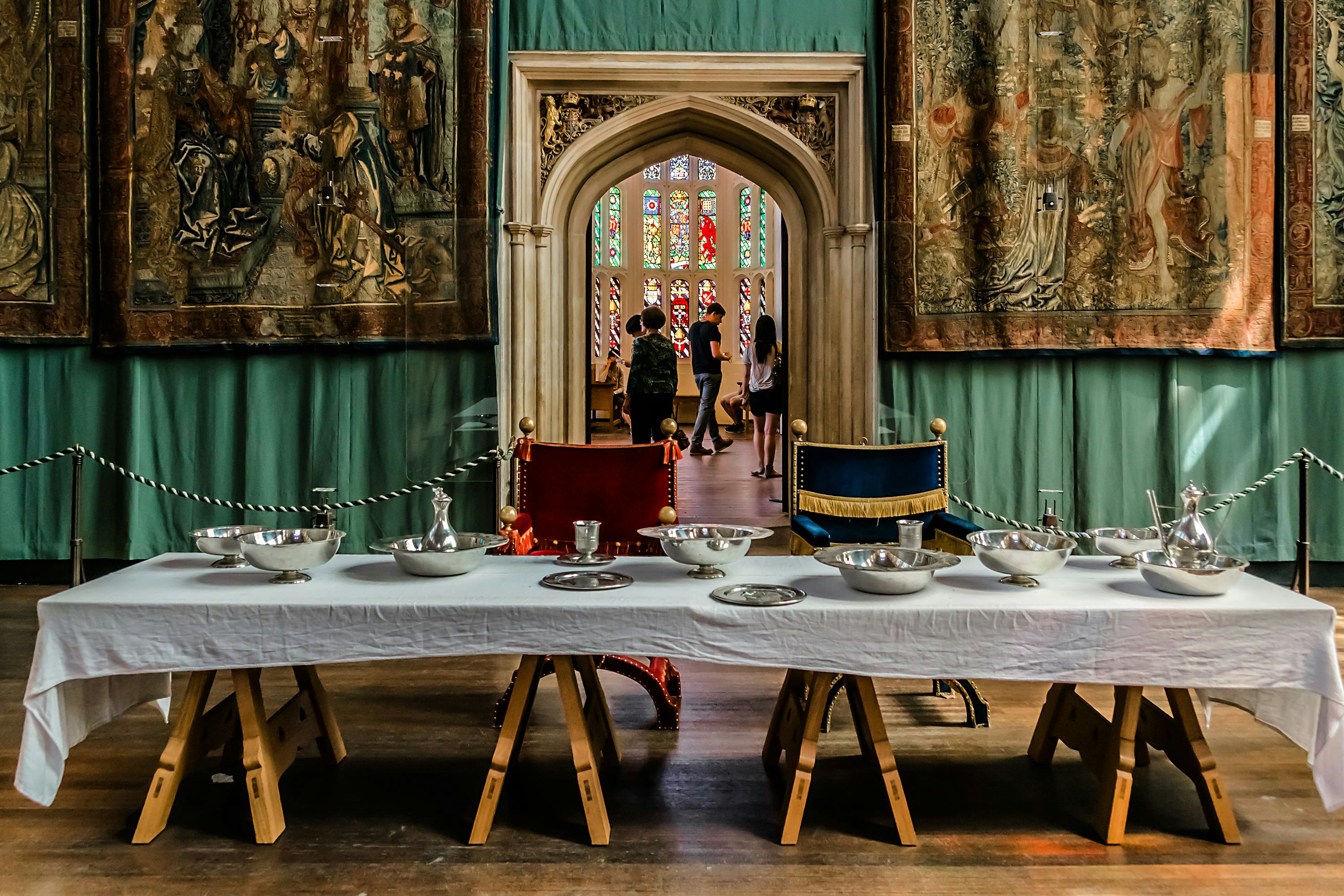 A royal table setting inside Hampton Court Palace in London, England, with tapestries behind. Kiev.Victor/Shutterstock