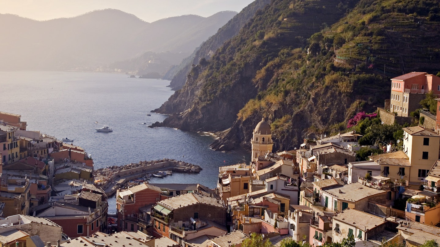 Italy's Cinque Terre: walking the Sentiero Azzurro between Corniglia and Vernazza. Looking down on the town of Vernazza.
italy, italia, italian, riviera, cinque terre, liguria, mediterranean, five lands, afternoon, evening, sentiero azzurro, sunet, vernazza, water, coast, mountains, haze, horizon, outdoors, buildings, harbour