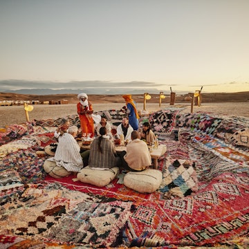 Wide shot of Moroccan waiters dressed in traditional attire serving friends and family tajine during sunset outdoor dining desert experience at luxury Agafay desert camp
2189646594
exotic travel