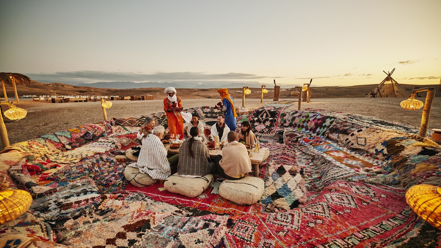 Wide shot of Moroccan waiters dressed in traditional attire serving friends and family tajine during sunset outdoor dining desert experience at luxury Agafay desert camp
2189646594
exotic travel