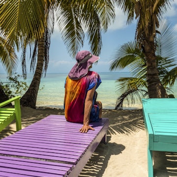 Woman sitting on a wooden tropical lounge bench. South Water Caye. Belize barrier reef island. Caribbean Sea.
901969590
getaway, tropical paradise, uncrowded, tropical resort, white sand beach