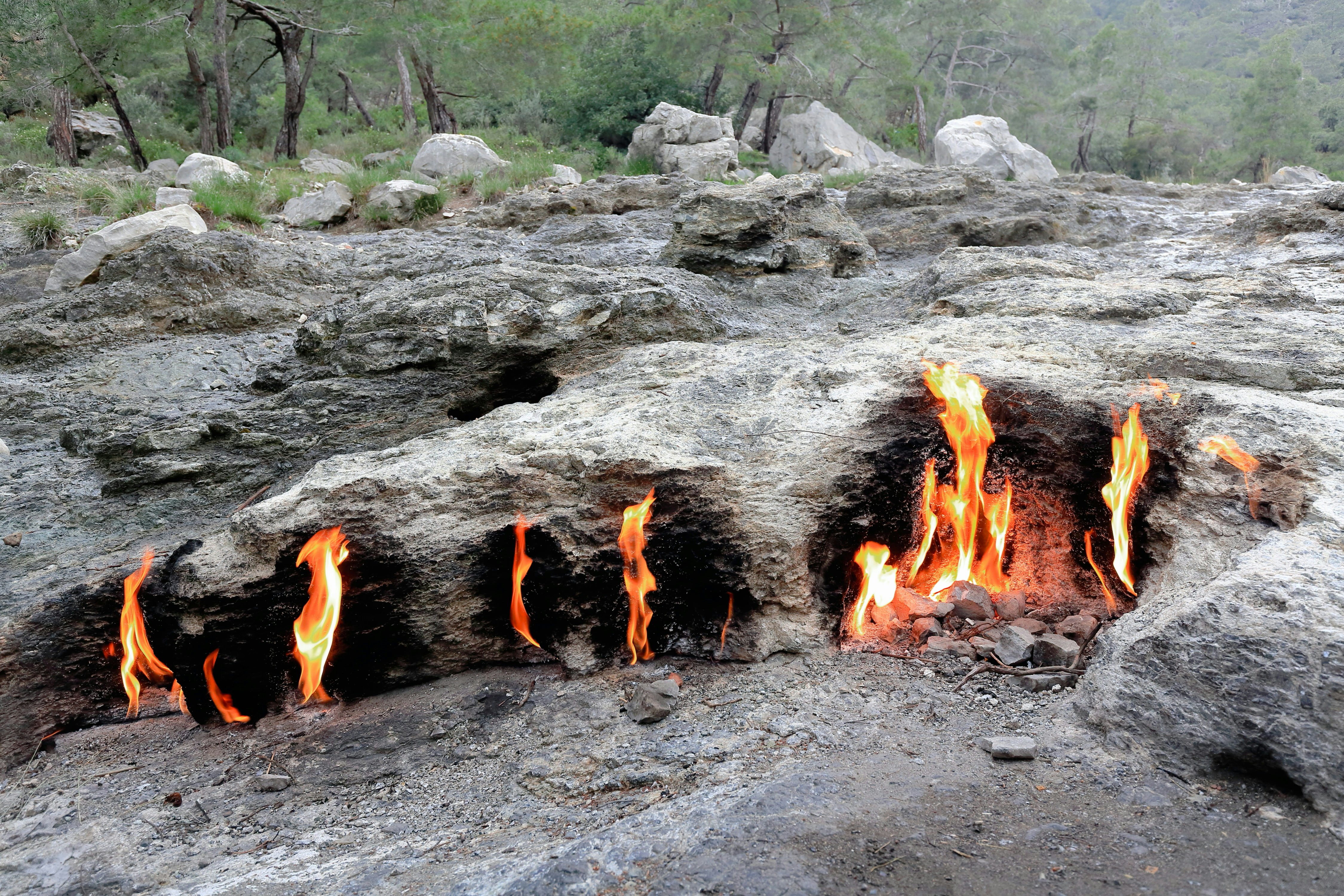 Flames burning from rock formations in the mountains in Turkey.