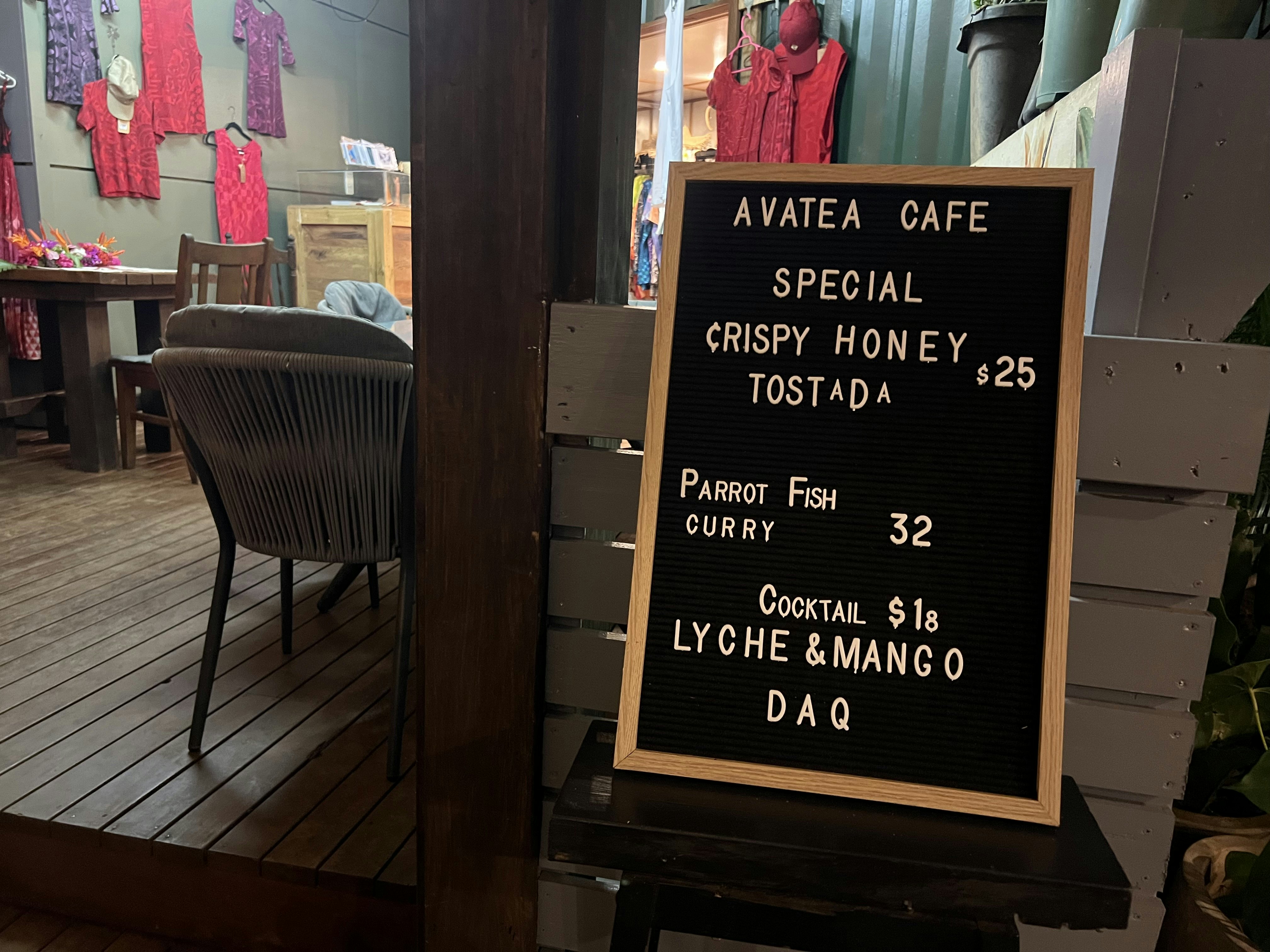A black board outside a small cafe shows the specials, including a tostada, a curry and a cocktail.