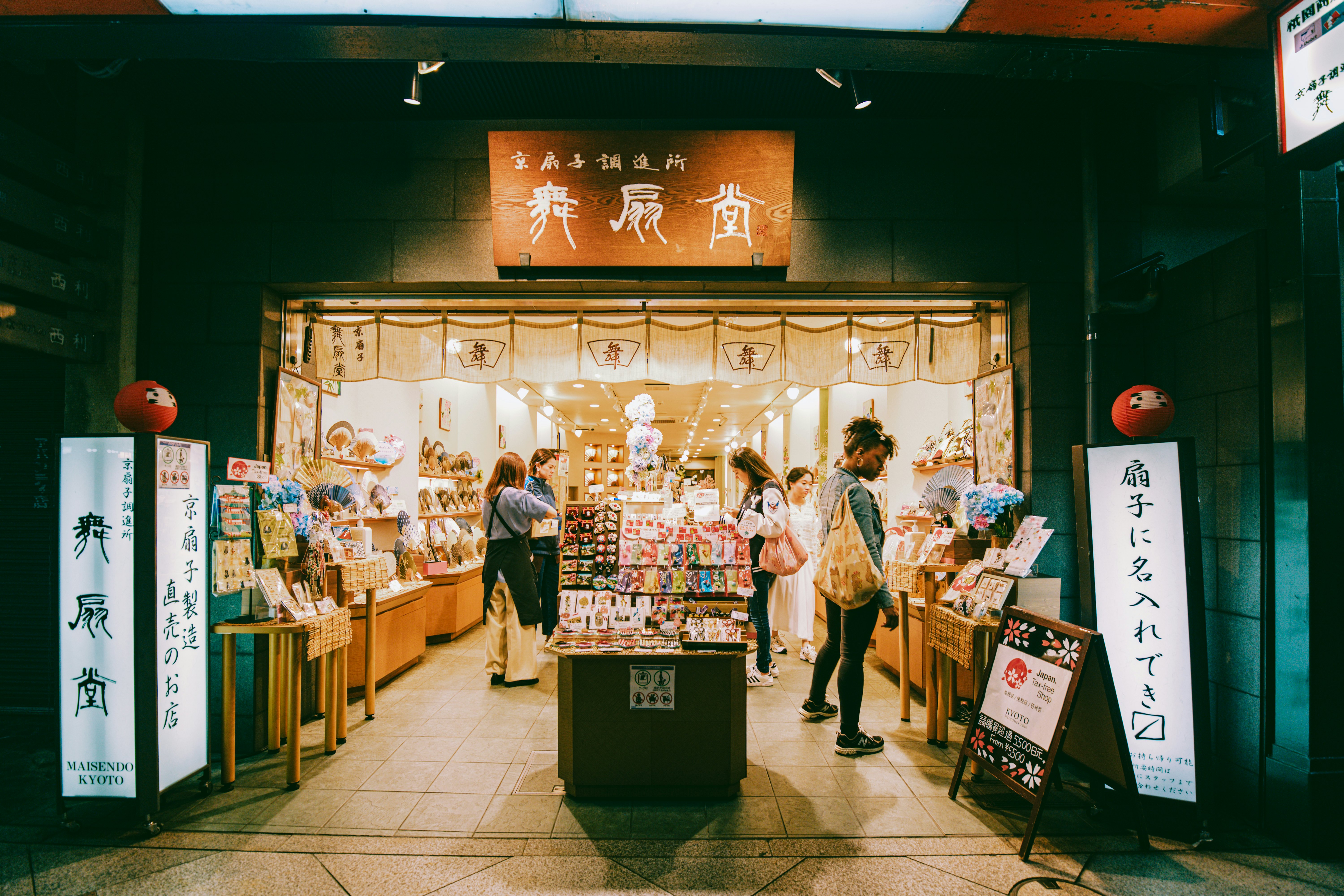 People browse around a shop with signs in Japanese and English outside it