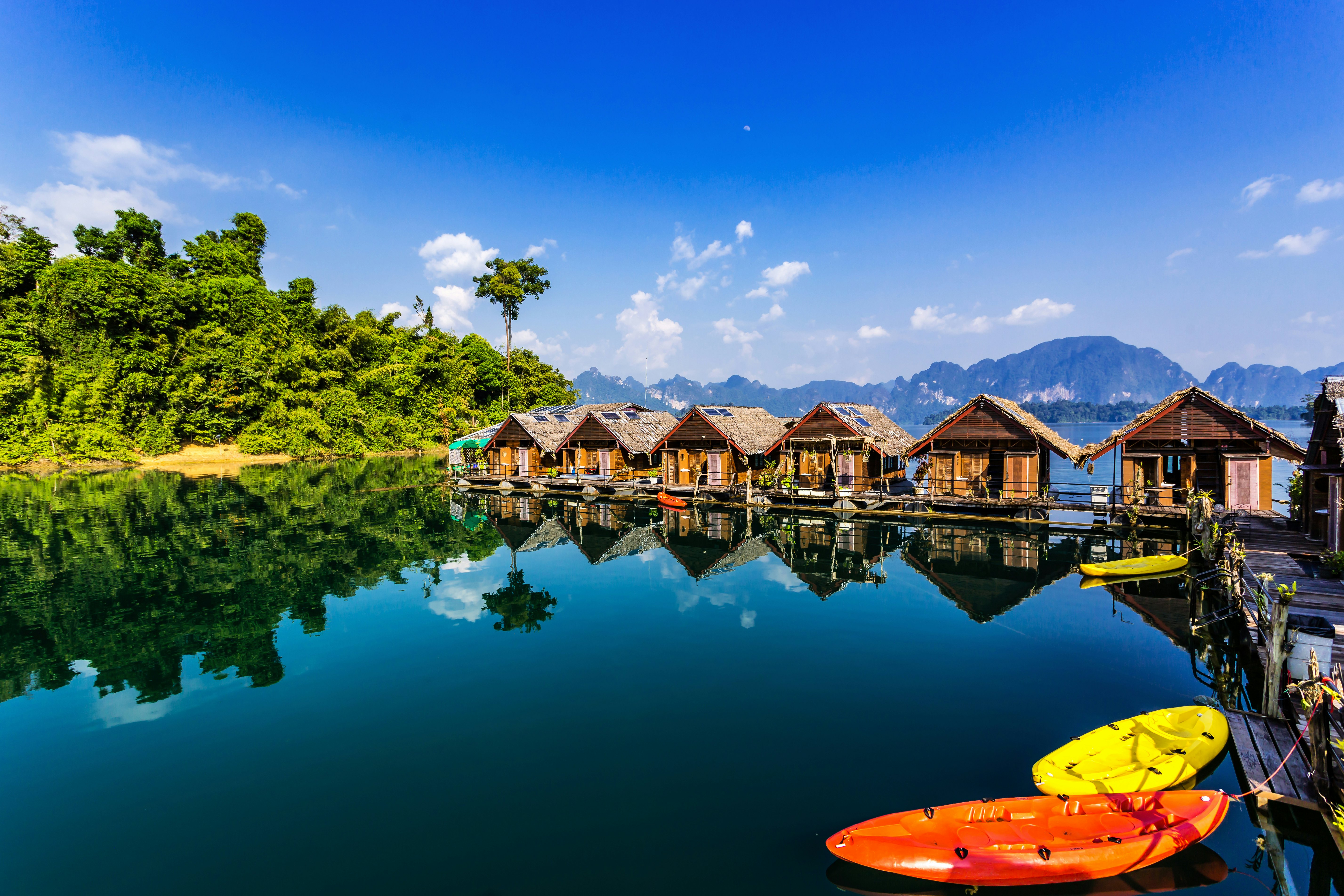 A row of over-water wooden bungalows appear to float in a massive lake.