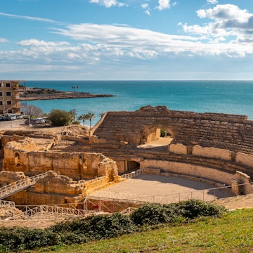 Ruins of Roman amphitheater by the Mediterranean sea, ancient touristic monument built during Roman empire, sunny weather, sea views and culture in Tarragona near Barcelona, Catalonia, Spain License Type: media Download Time: 2021-04-15T11:09:18.000Z User: gwencotter Is Editorial: No purchase_order: