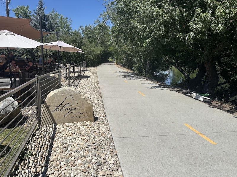 The path of the Greenbelt with the patio of Telaya Winery next to it in Boise, Idaho