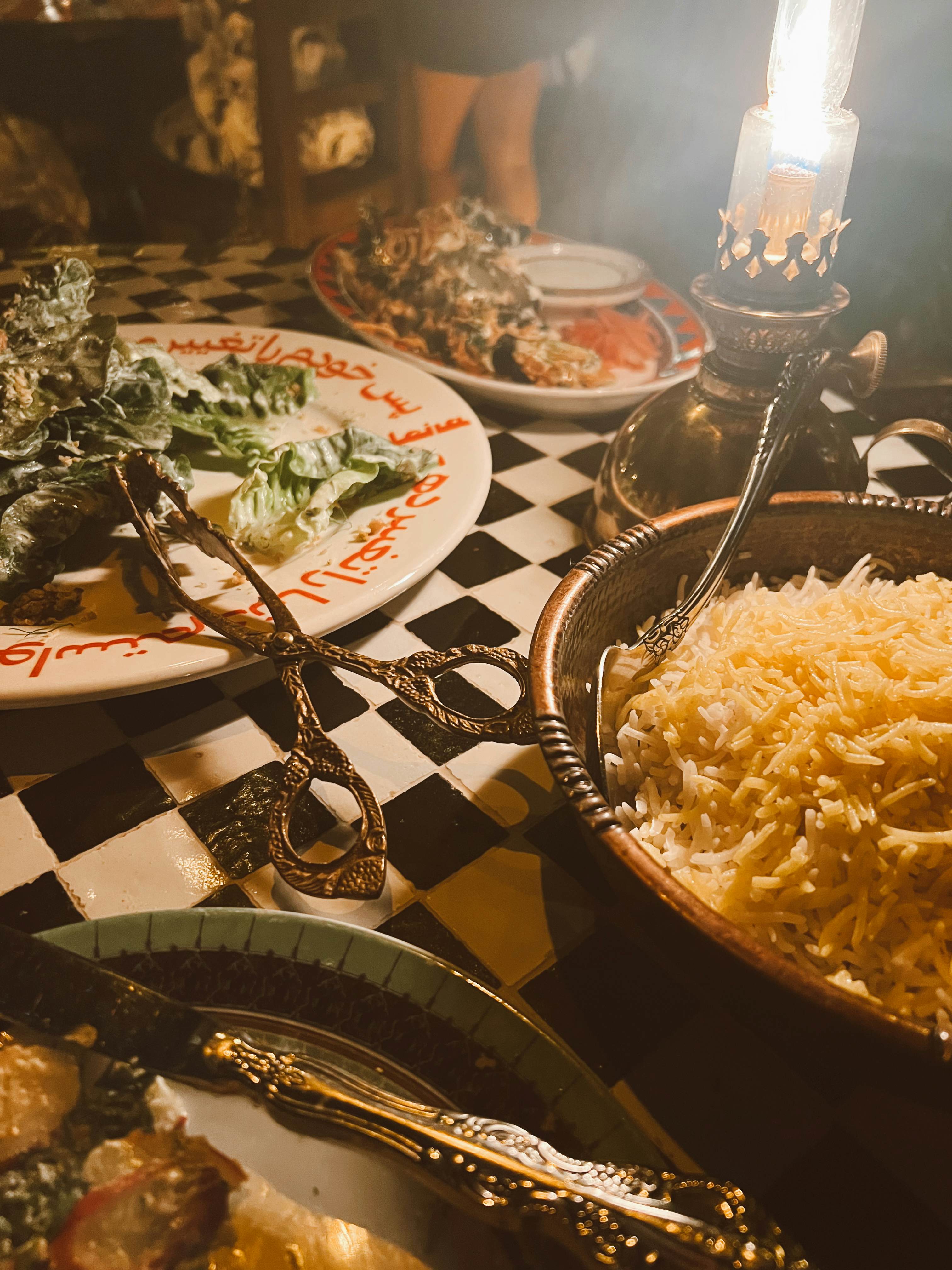 Close-up of plates of food on a table with serving implements.
