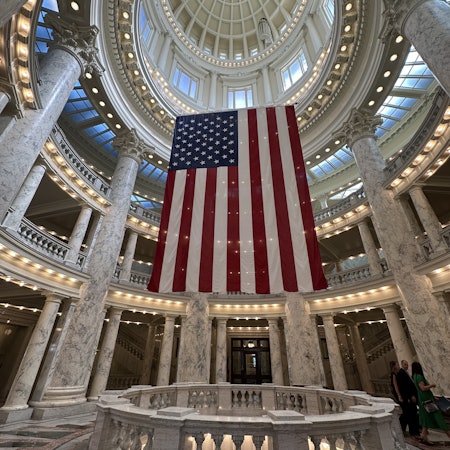 Rotunda with lights and a large US flag hanging from the ceiling