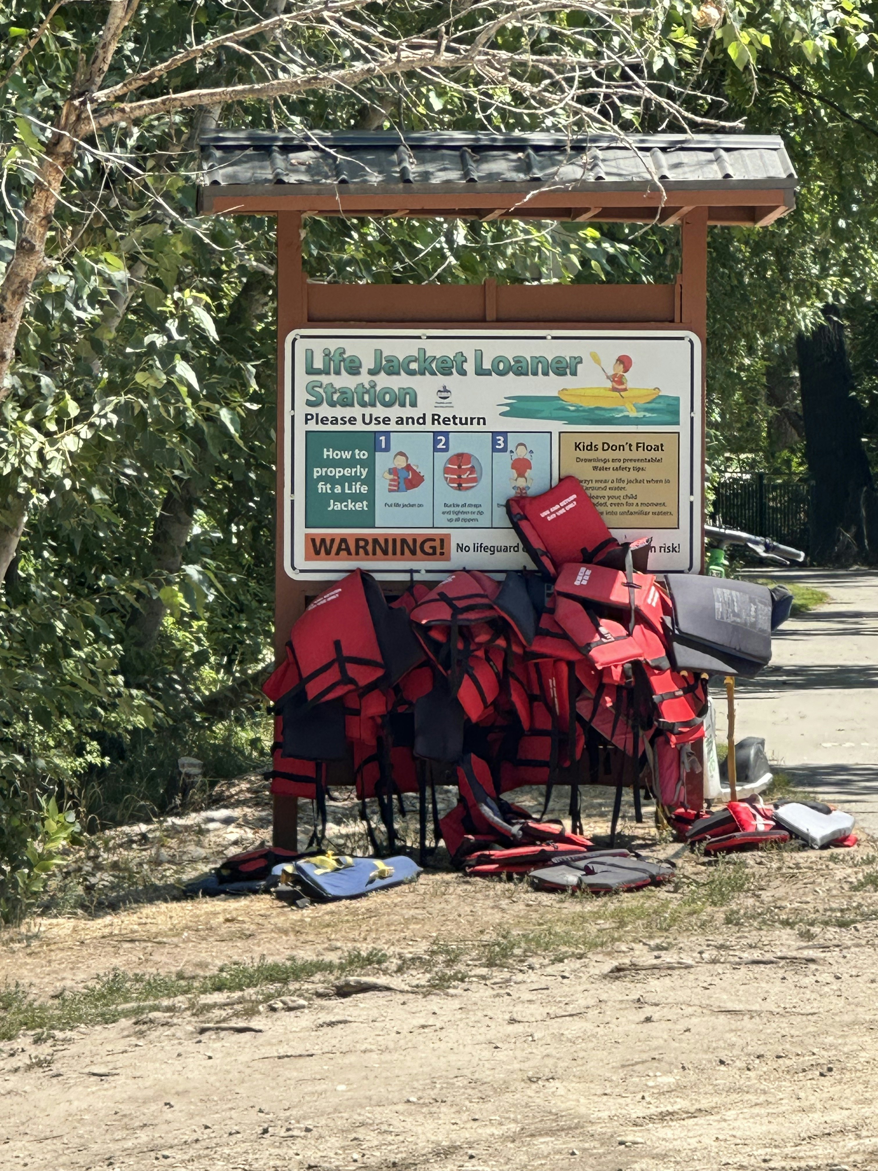 Red life jackets hang on a kiosk along the Boise, Idaho.