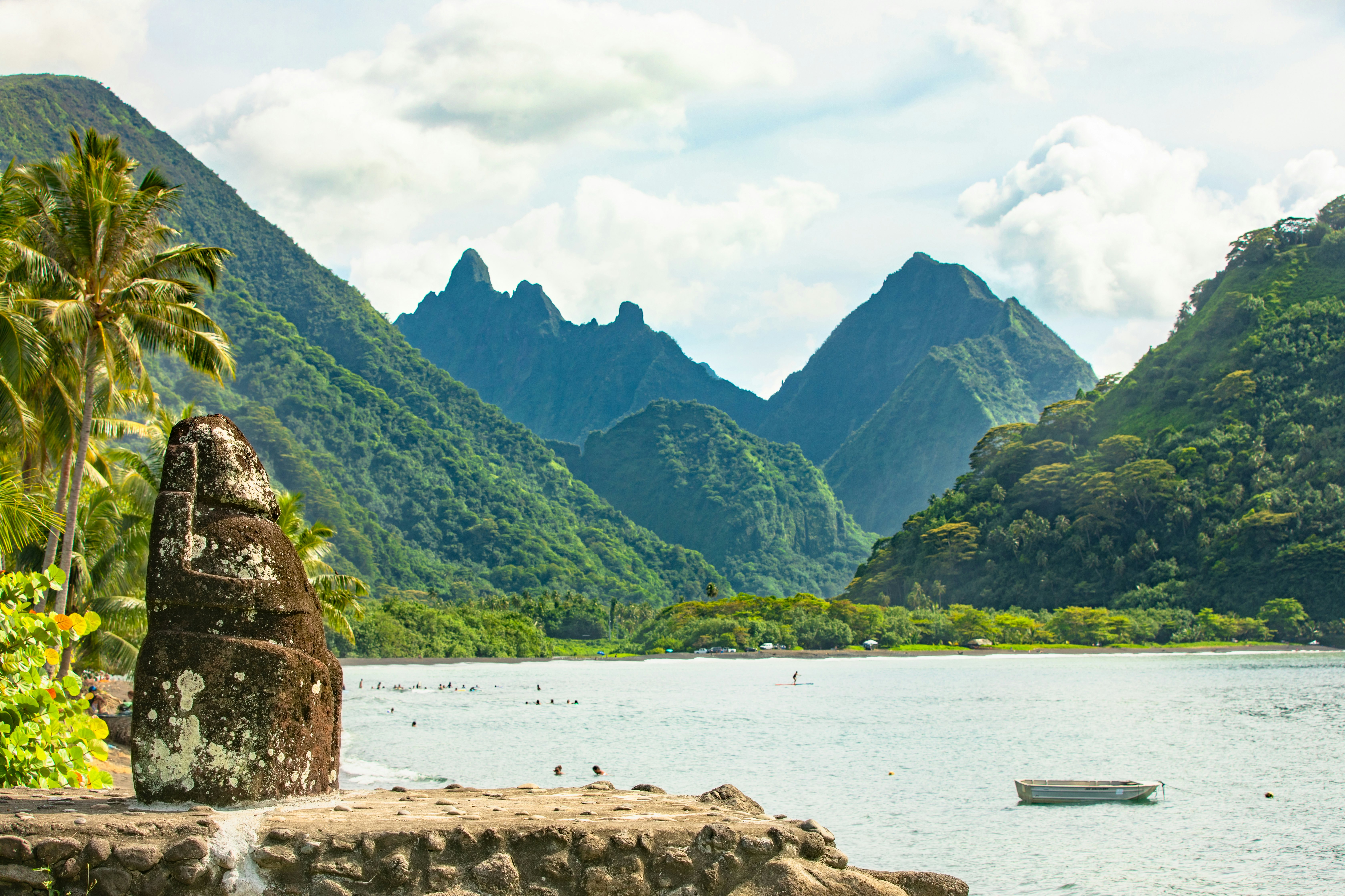 Lush hillsides and pointed peaks covered in green at the edge of a waterway.