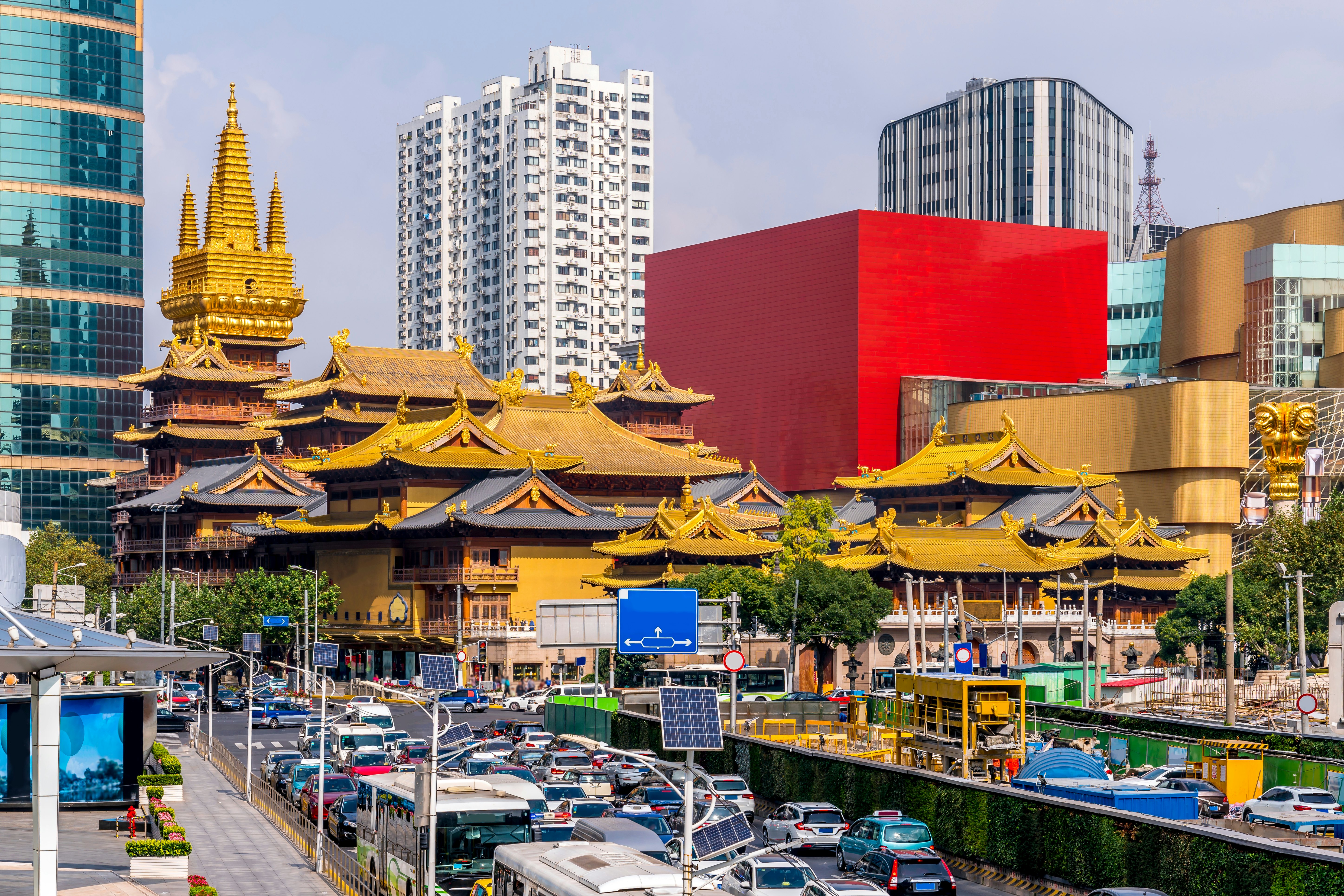 The golden rooftops of the Jing'an temple in Shanghai, China, ringed by modern buildings.