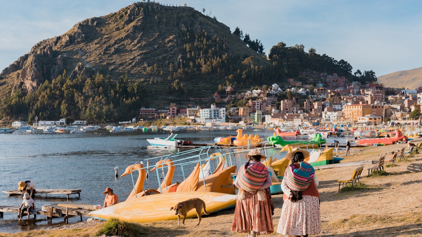 women in traditional clothes walking along the beach of Lake Titicaca, in front of the Calvary hill in Copacabana - Bolivia, License Type: media, Download Time: 2025-08-18T11:51:38.000Z, User: clairenaylor, Editorial: false, purchase_order: 65050 - Digital Destinations and Articles, job: Online editorial, client: Bolivia things to do, other: Claire Naylor
