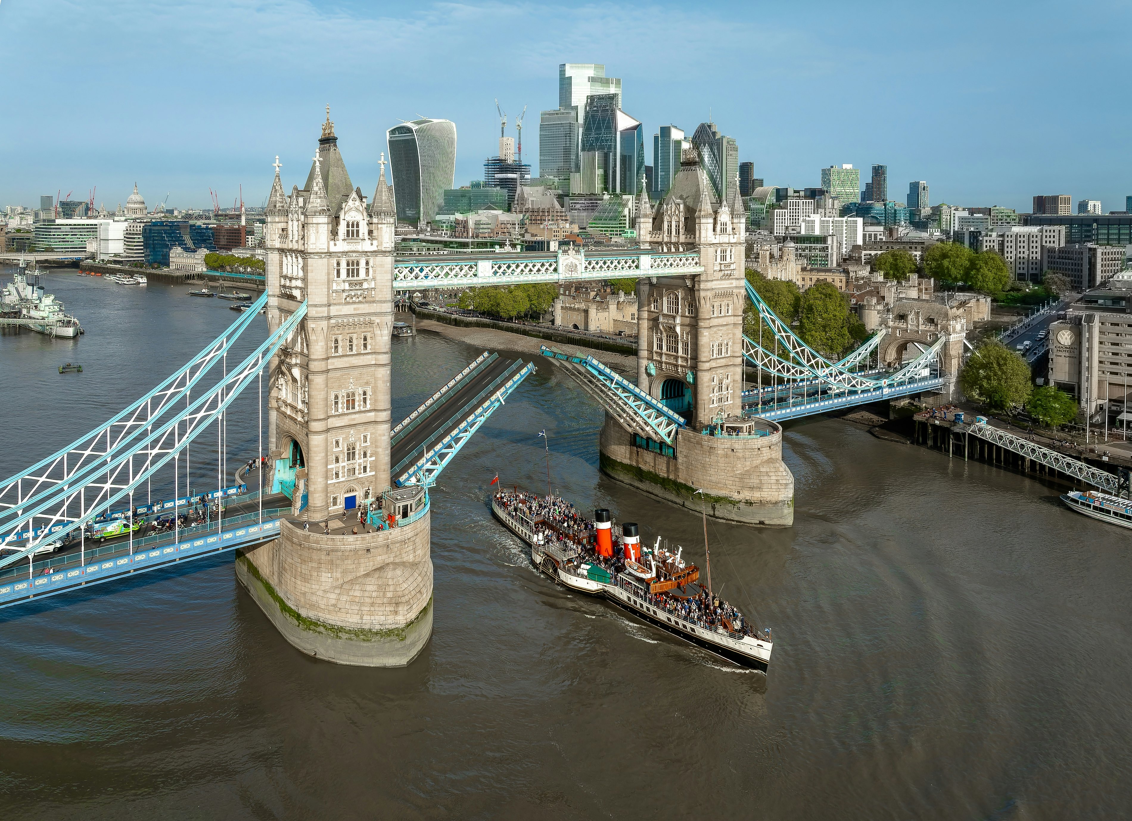 A steamer going under a bridge with two towers that spans a river