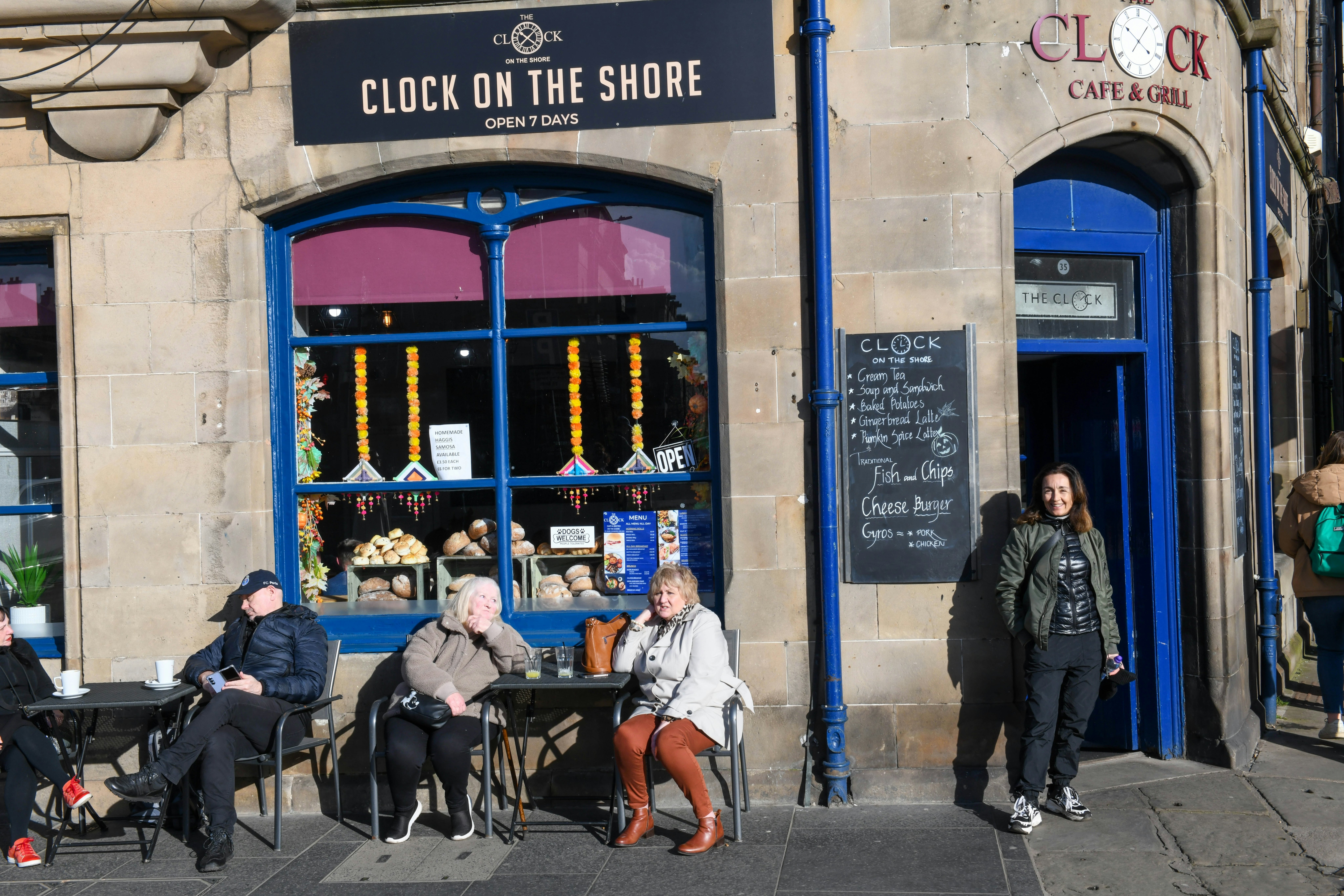 People at tables in front of a cafe in Leith