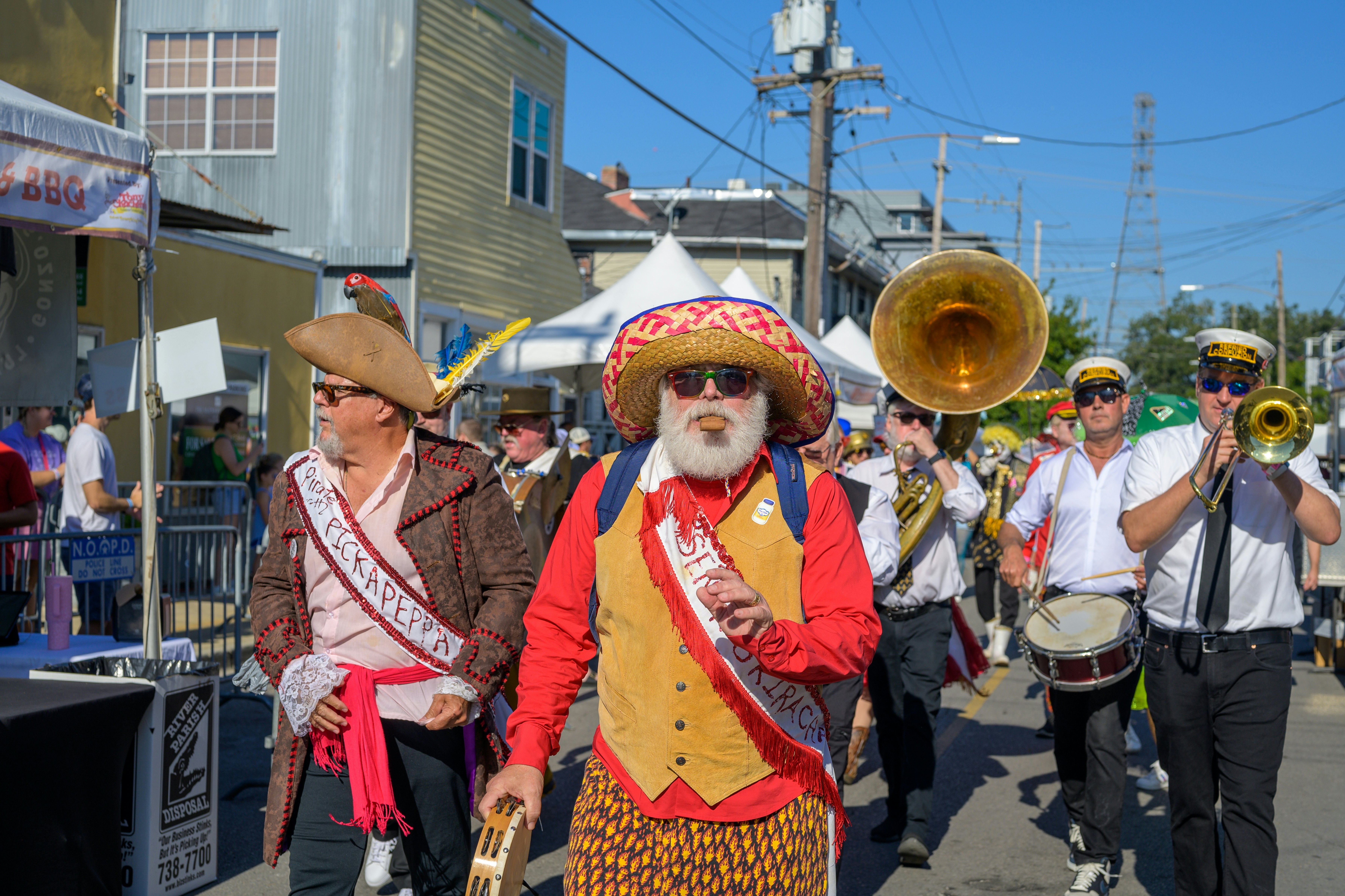 The Po-Boy Festival on Oak Street, with a marching band and men in colorful outfits
