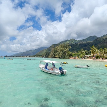 Moorea, French Polynesia - 09282024: Scenic view of tropical island of Mo'orea in South Pacific with crystal clear turquoise ocean water, tour rental boats, and mountainous landscape, License Type: media, Download Time: 2025-04-16T20:31:31.000Z, User: carolfarrell170, Editorial: true, purchase_order: 56530 - Guidebooks, job: Global Publishing WIP, client: Tahiti & French Polynesia 12, other: carol farrell