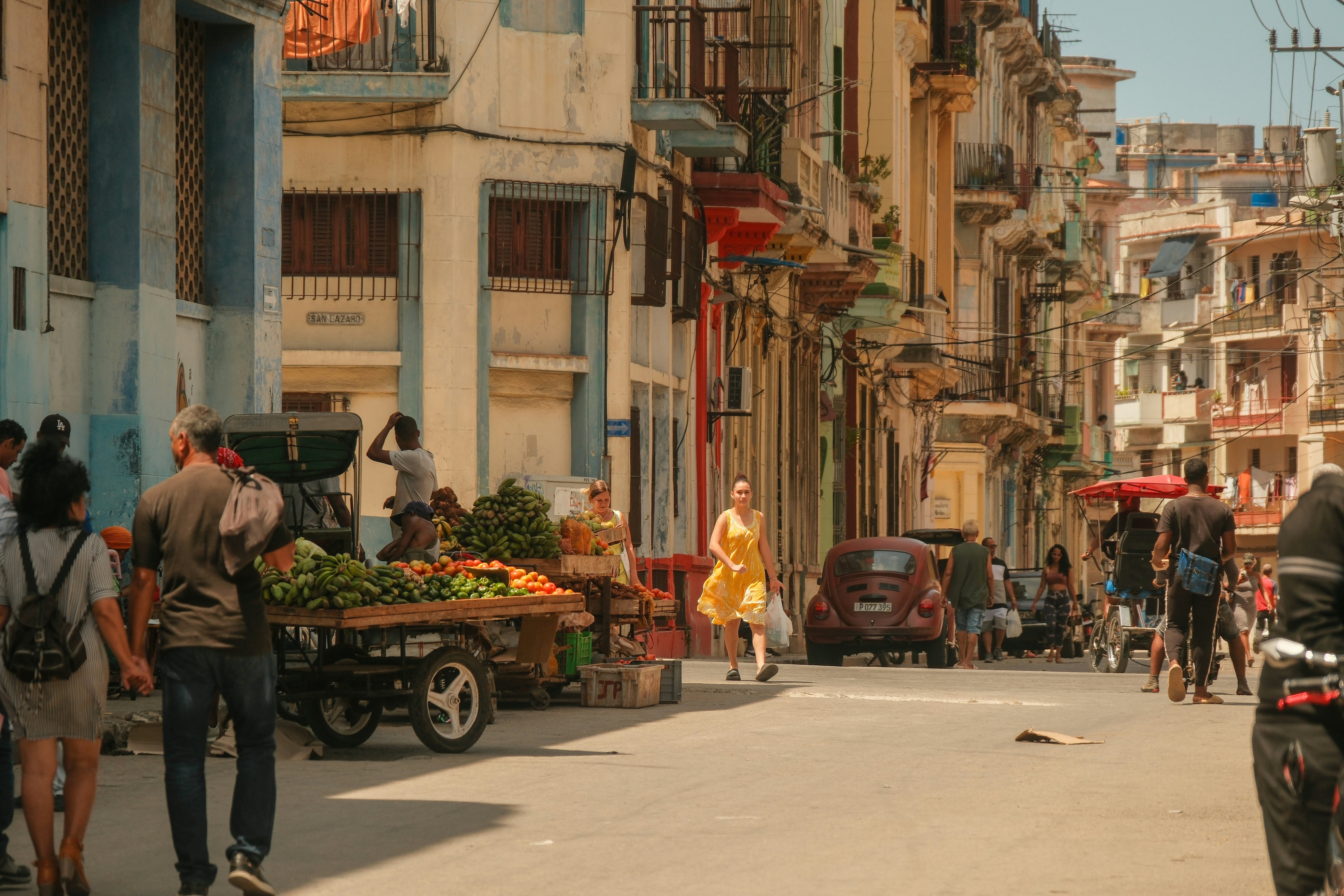 A street in Old Havana. People walking on the streets, vendors selling fruits in carts. Bustling vibrant city life in neighbouhood