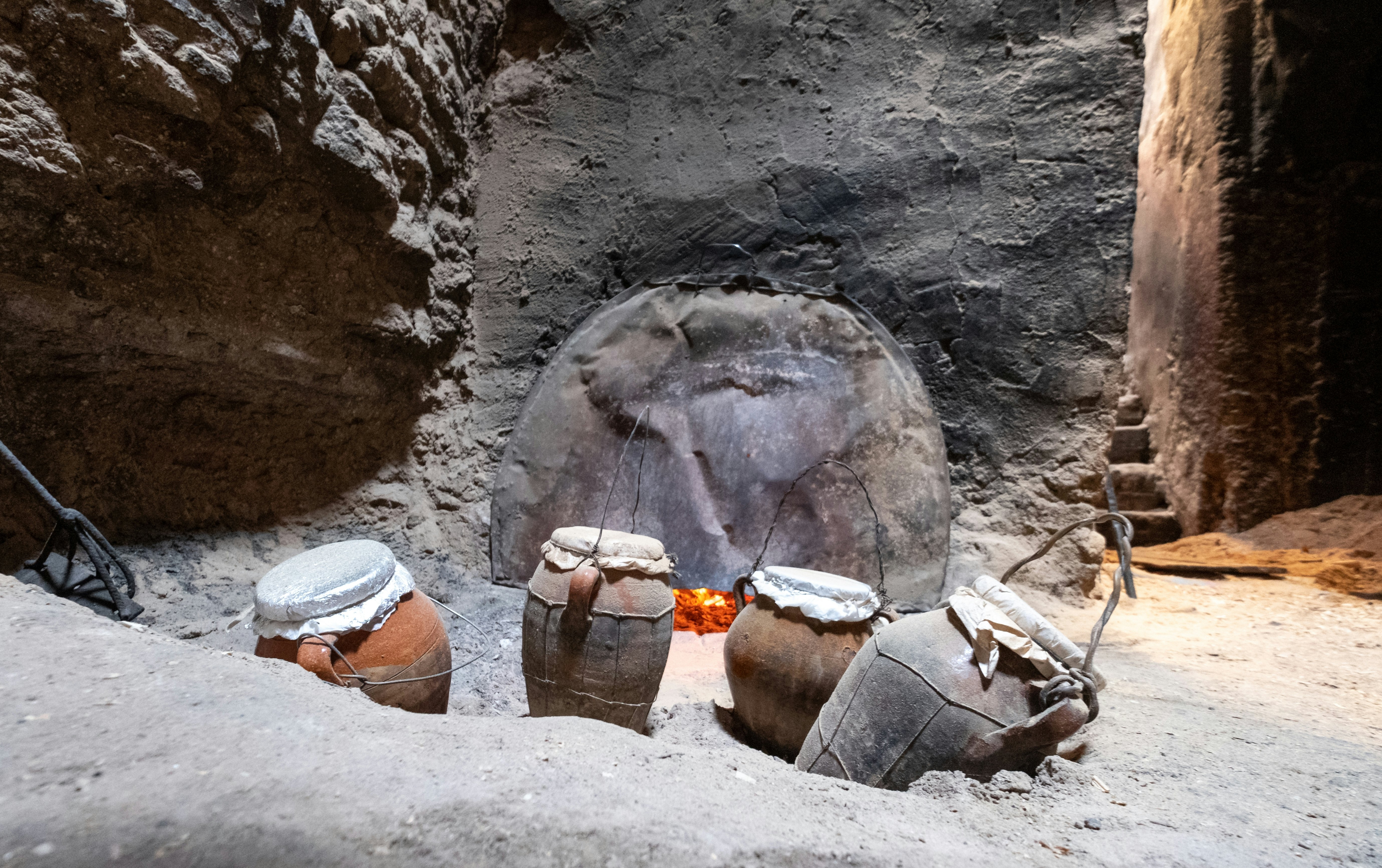 Tanjia cooking vessels deep in ash, heated by the adjacent Hammam hot baths. The food in the clay tangia vessels cooks slowly over many hours. Photographed in the old town medina in Marrakech, Morocco