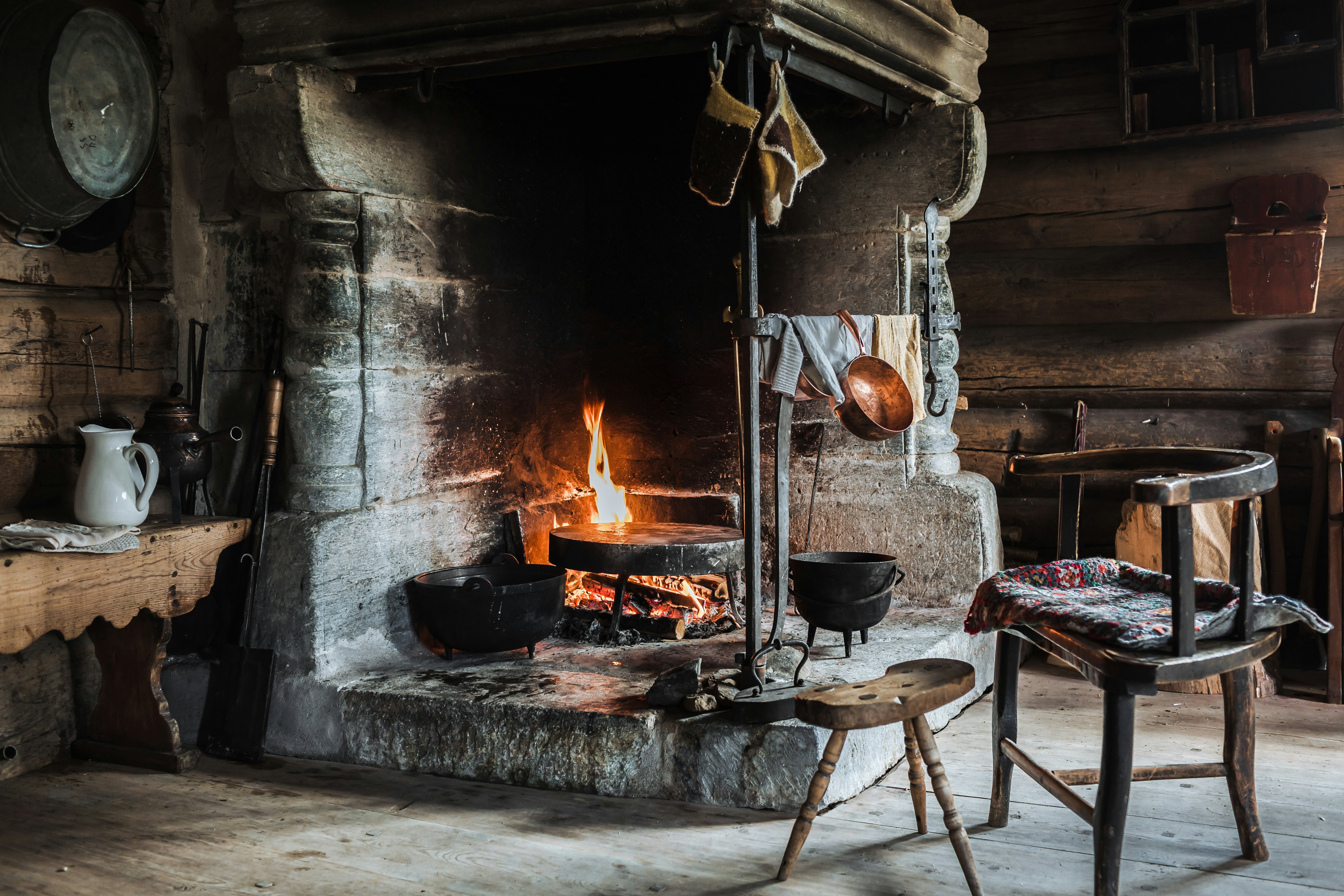 A fire burns in a traditional stone hearth in a reconstructed country dwelling in Lillehammer, Norway.