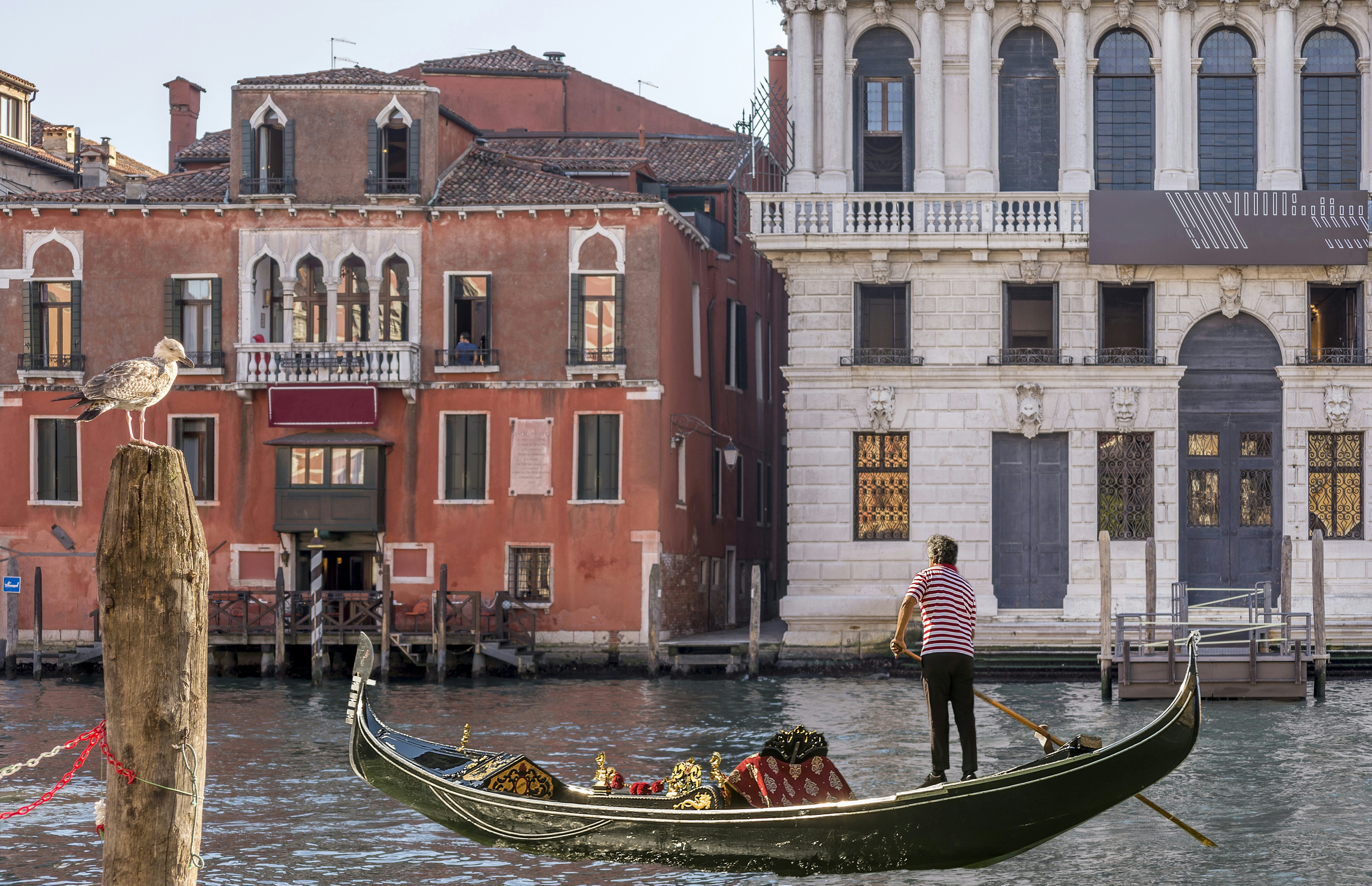 A gondola sails on the Grand Canal near the Hotel San Cassiano and the Prada Foundation, Ca' Corner della Regina, Venice, Italy