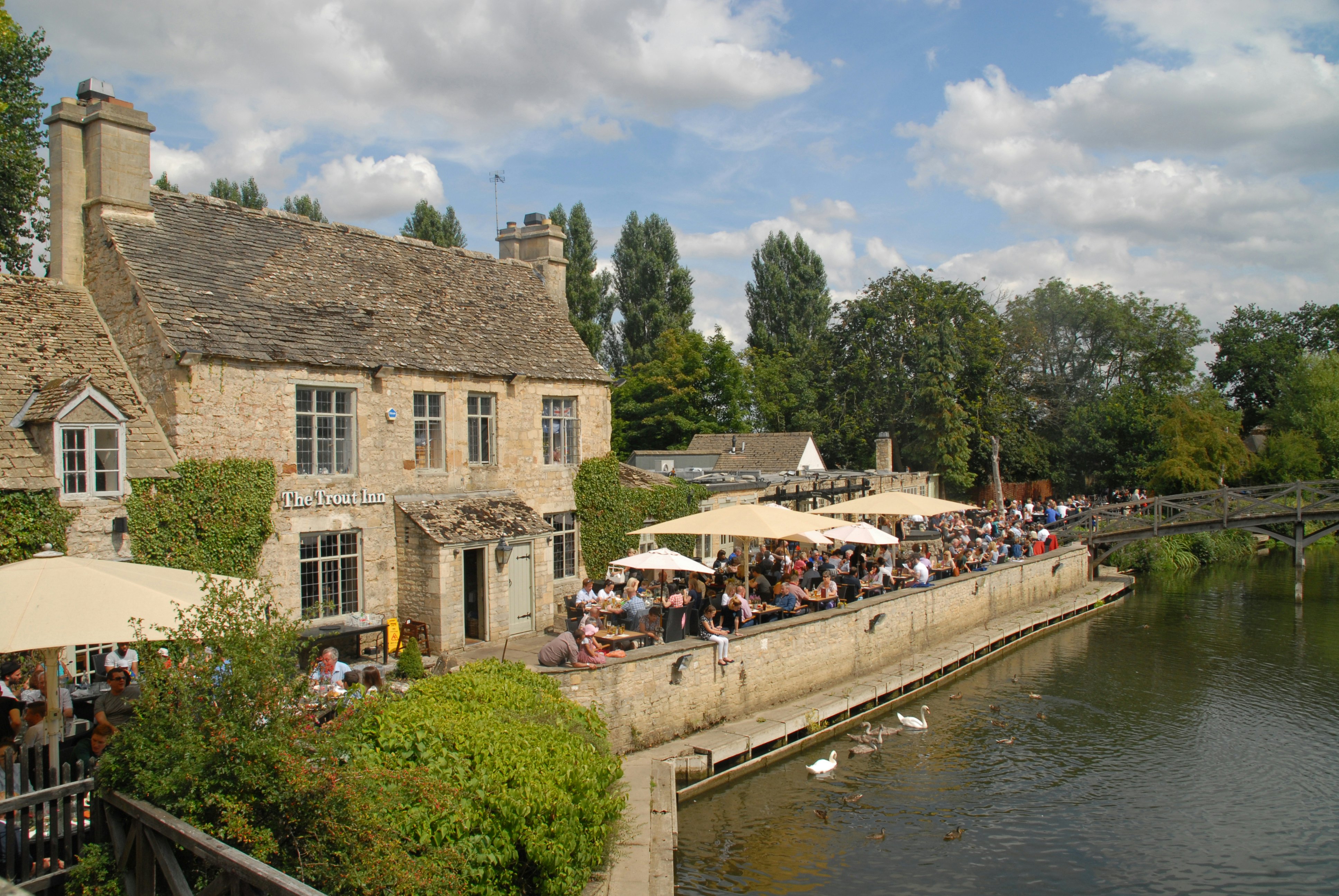 People drinking by the river side in the Trout Inn at Port Meadow, Oxford, England.