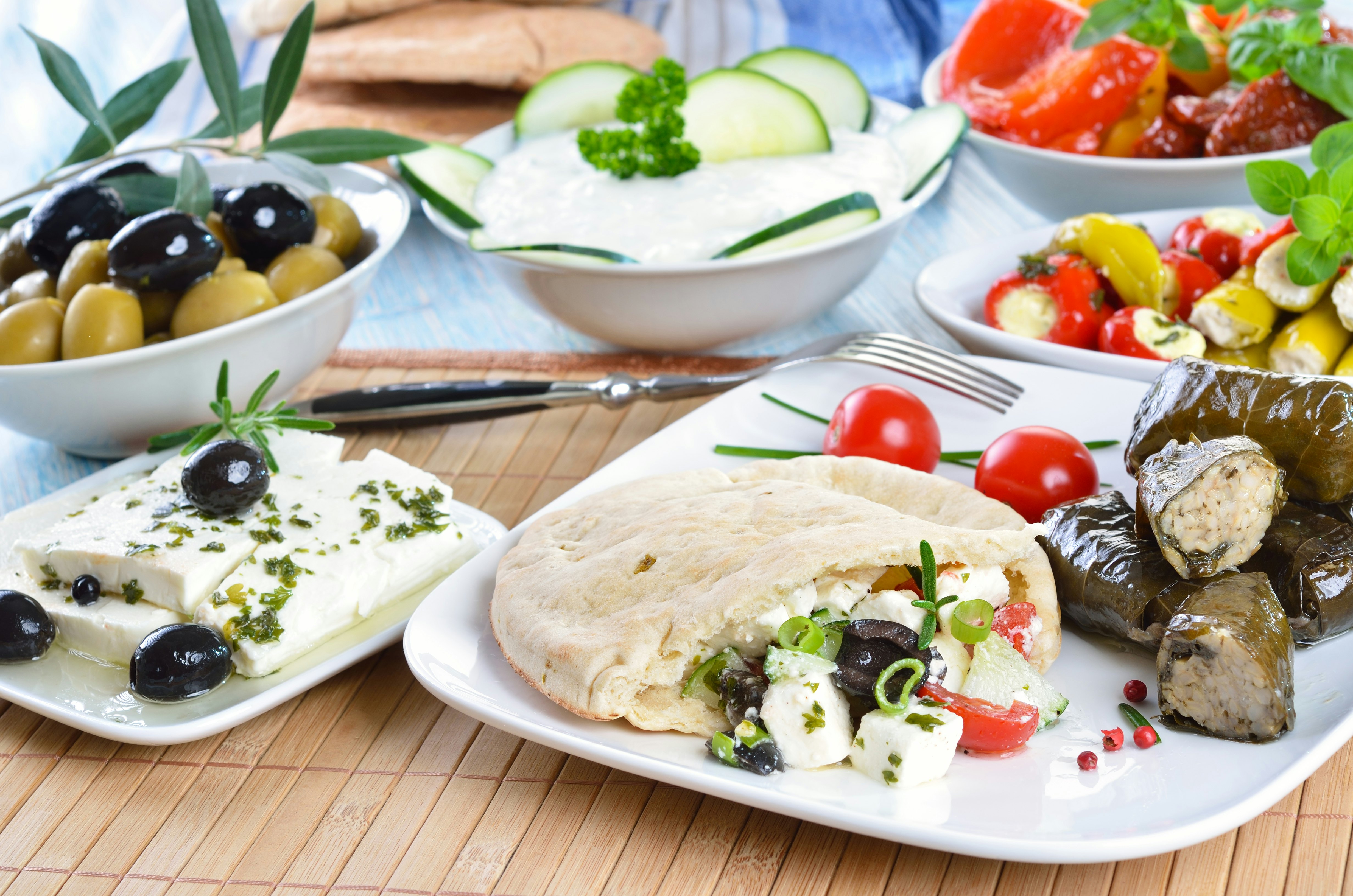 Greek appetizers including stuff pita, feta cheese, stuffed vine leaves and salads