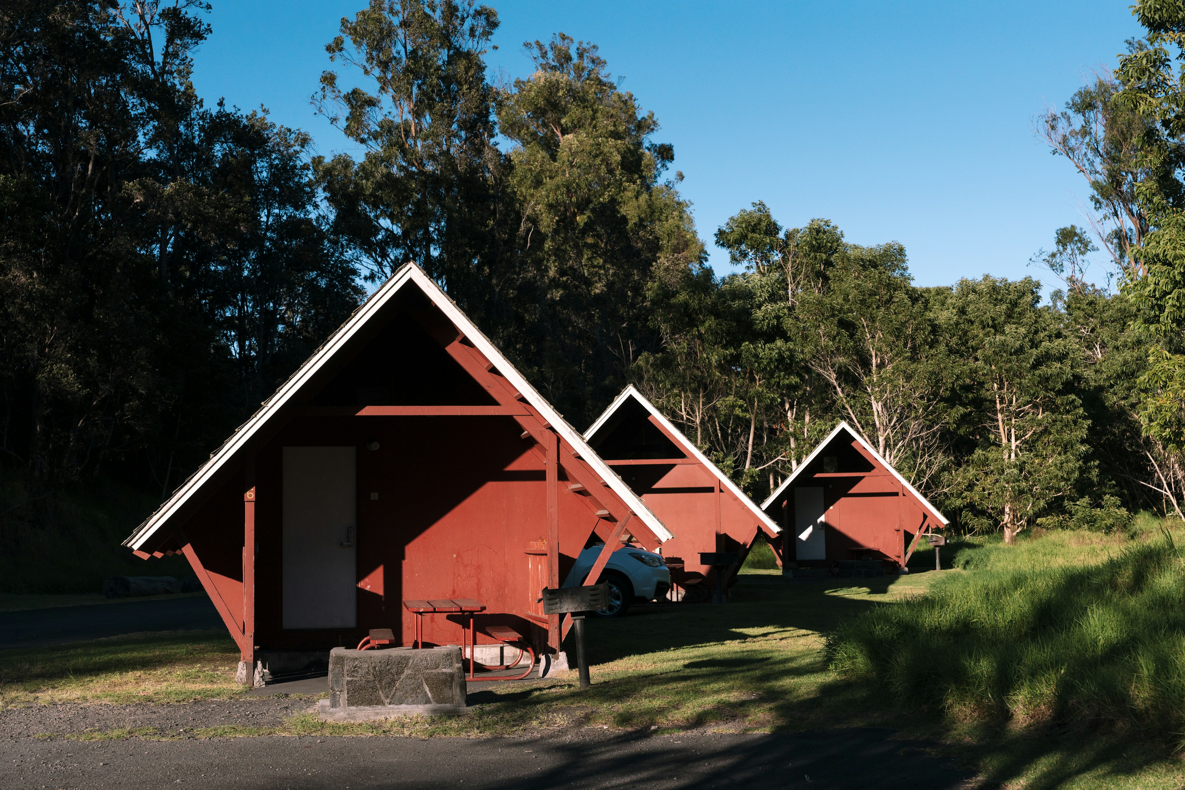 Three small red A-frame cabins