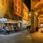 ancient, antique, arc, arcade, arch, architectural, architecture, bologna, building, cafe, center, chair, city, cityscape, cozy, emilia, europe, european, evening, historic, historical, house, italia, italian, italy, landmark, medieval, narrow, night, old, outdoor, passage, people, restaurant, romagna, street, table, terrace, tourism, tourist, town, travel, urban, view
Old narrow street with arcade in Bologna, Emilia Romagna, Italy. Night cityscape of Bologna.