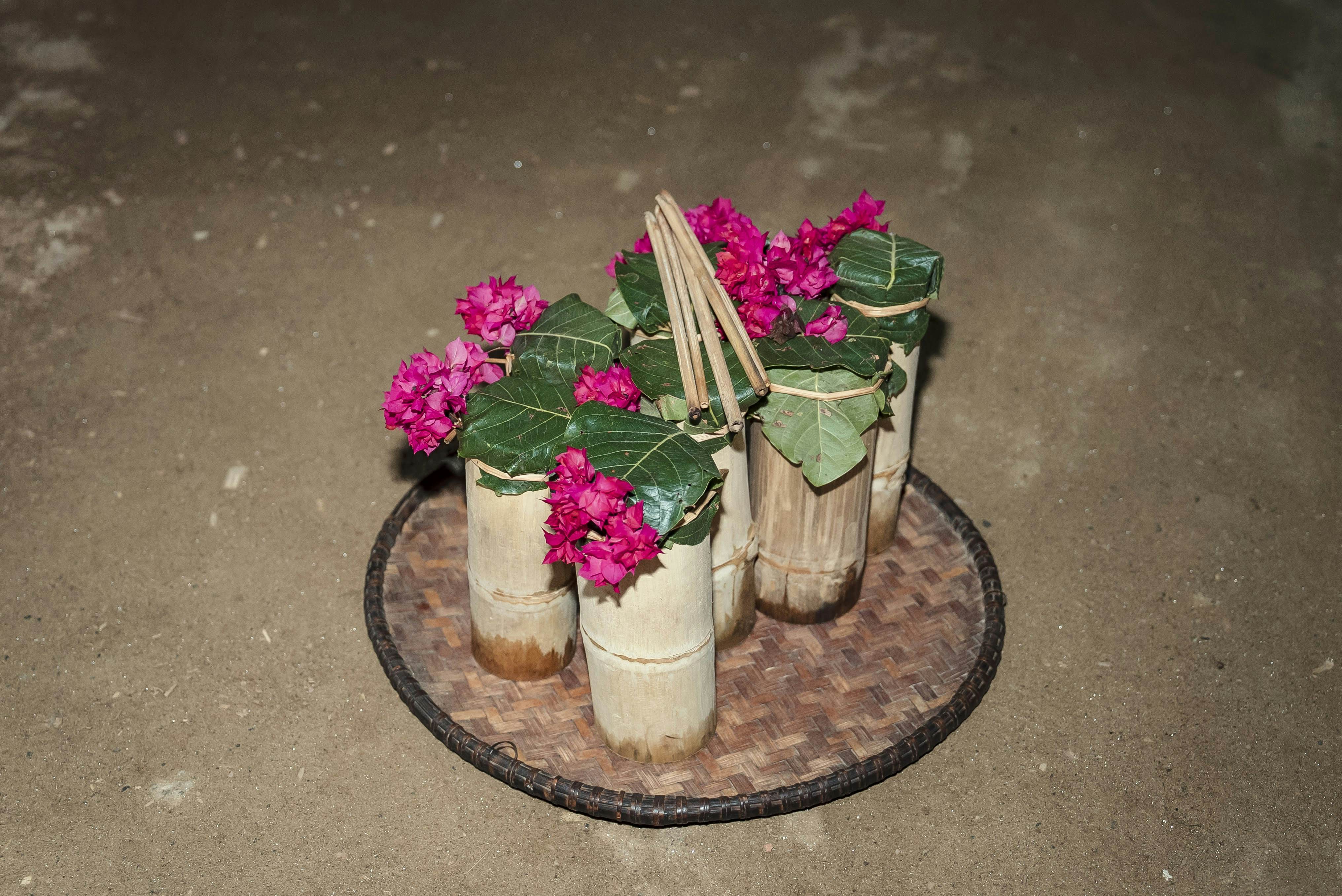 A tray of bamboo pitchers with bougainvillea.