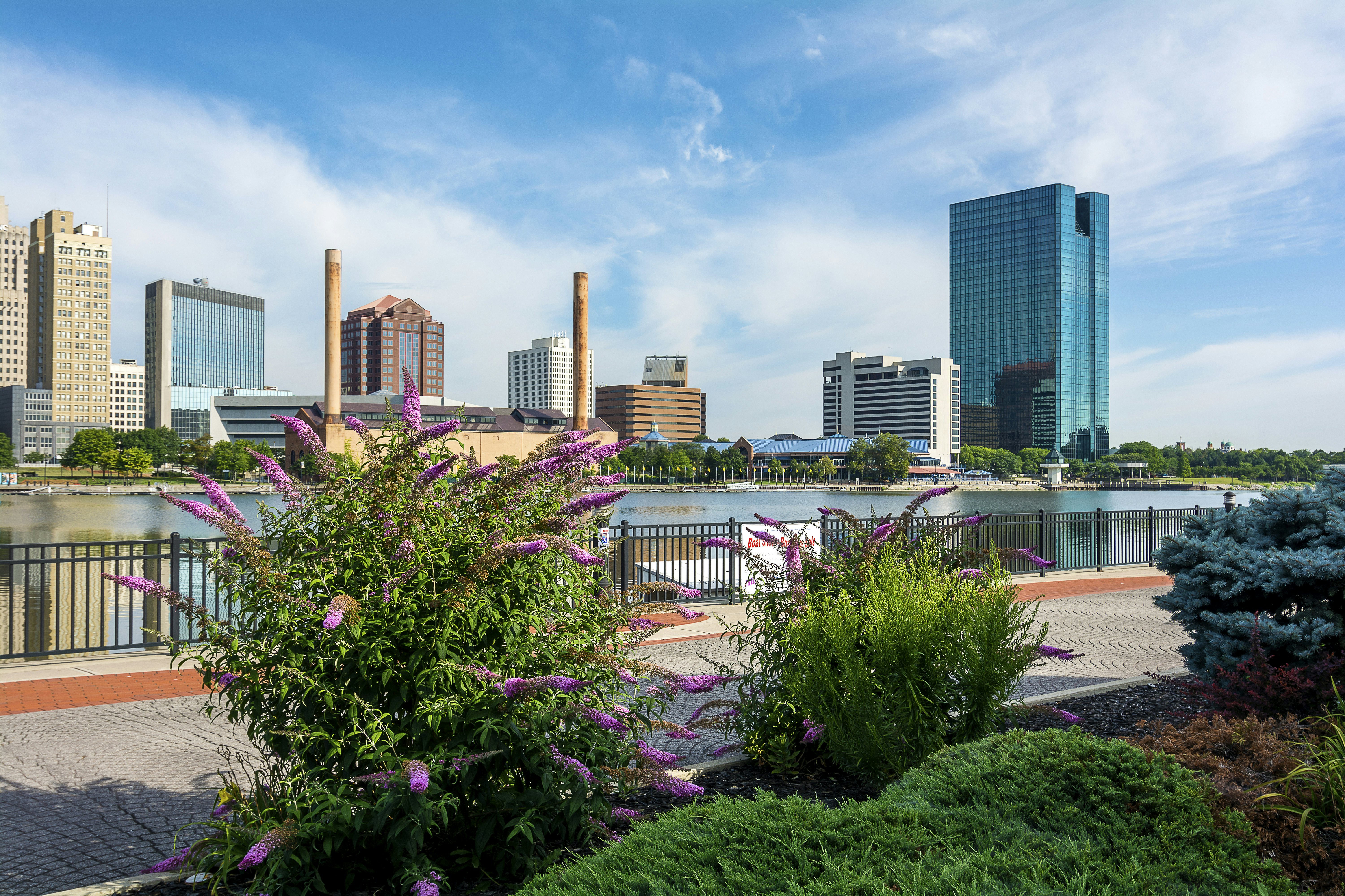 A panoramic view of downtown Toledo Ohio's skyline from across the Maumee river at the Docks. A beautiful blue sky with white clouds for a backdrop.