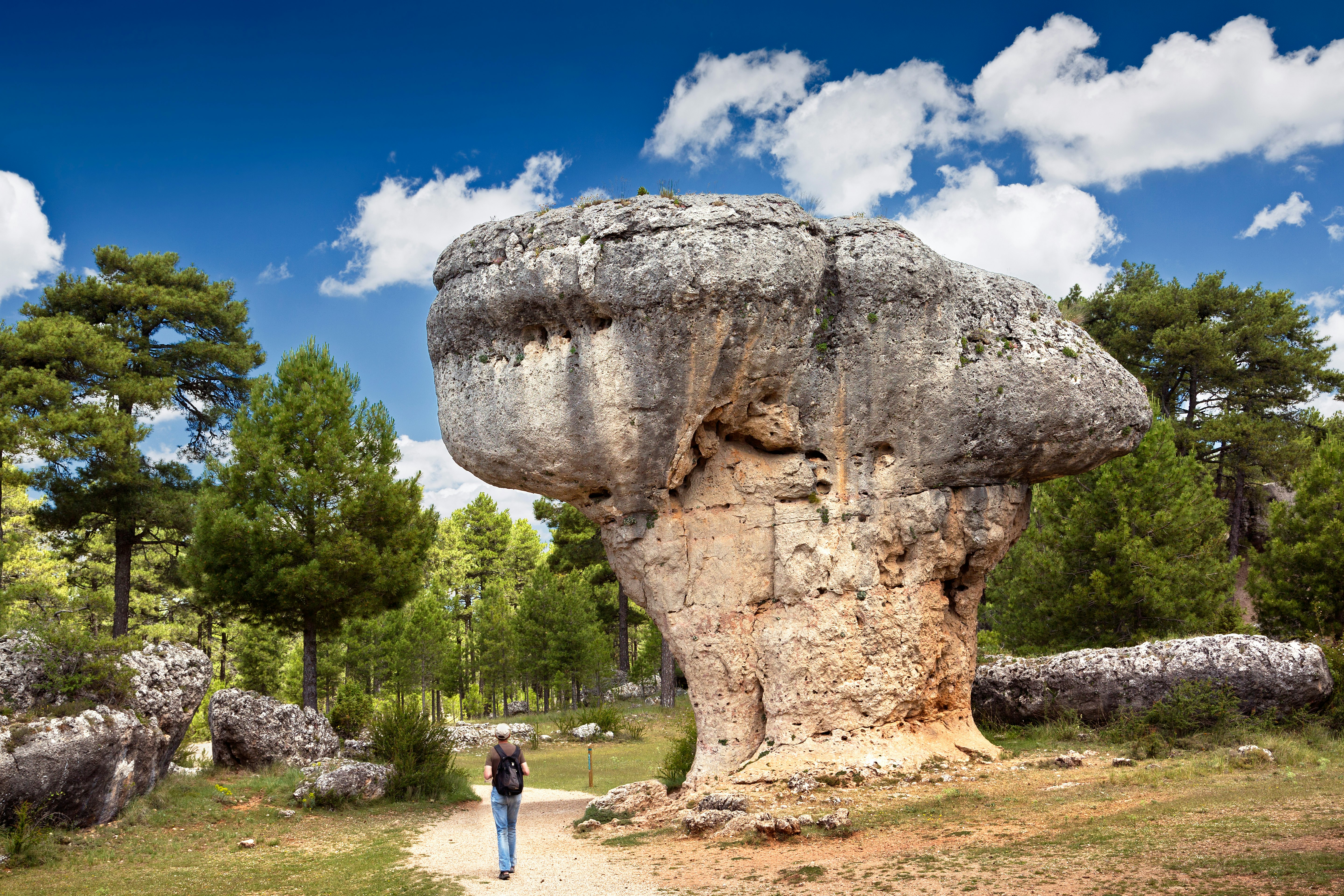 Landscape with man observing the karst rock formations of Ciudad Encantada (enchanted city) at the Serrania de Cuenca natural park, near the city of Cuenca in Spain.